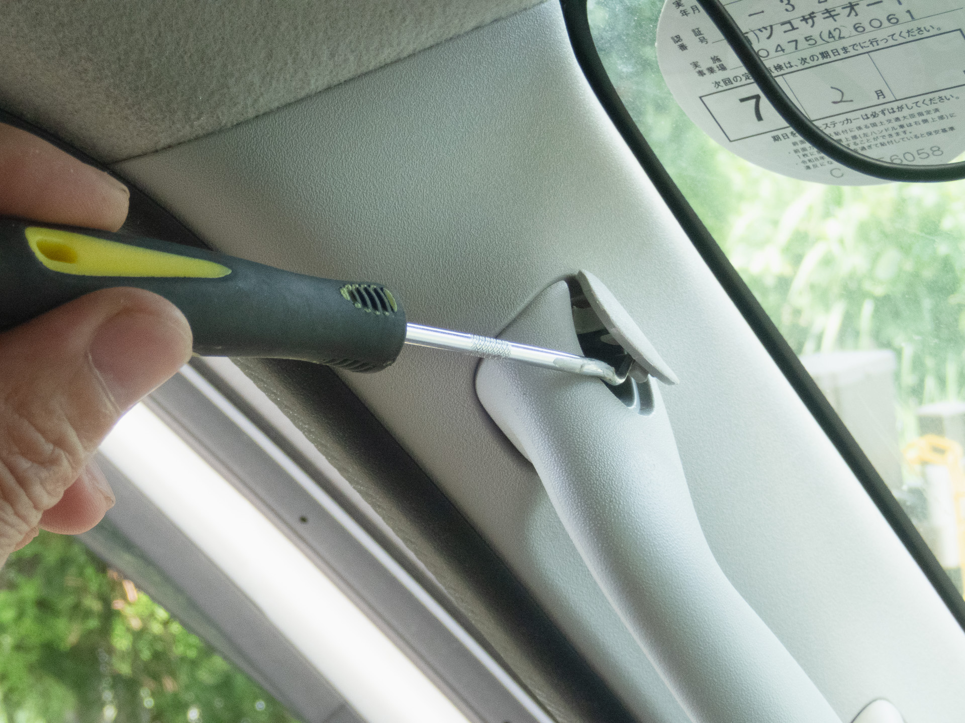 助手席側Aピラーのハンドルを外す。カバーをピックツールで外すと、10mmの6角ボルトがある