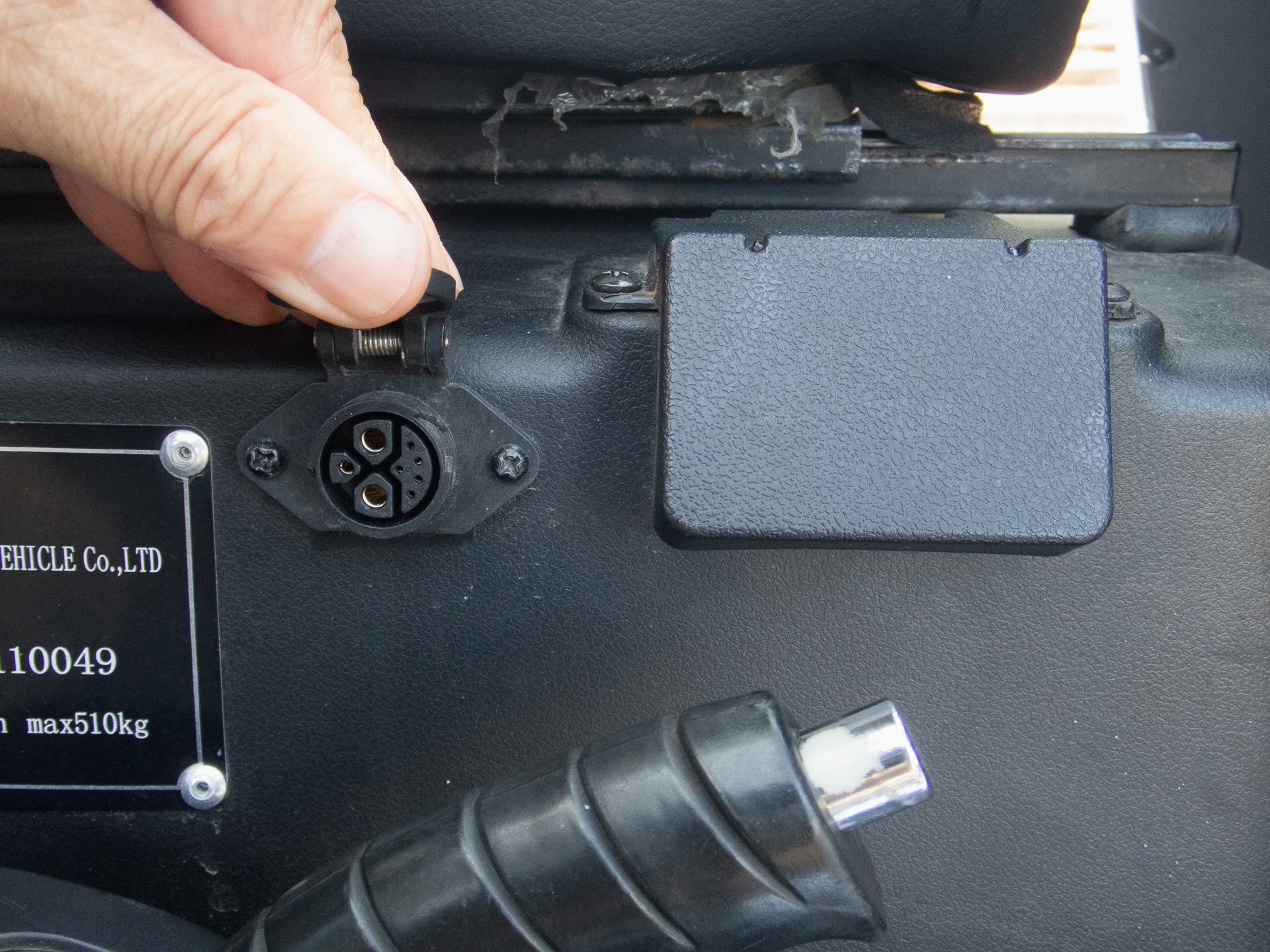 コーションプレート脇に充電コネクター。その右脇のカバーを開けるとメインブレーカーが設置されている。ブレーカーは異常時に確認するため