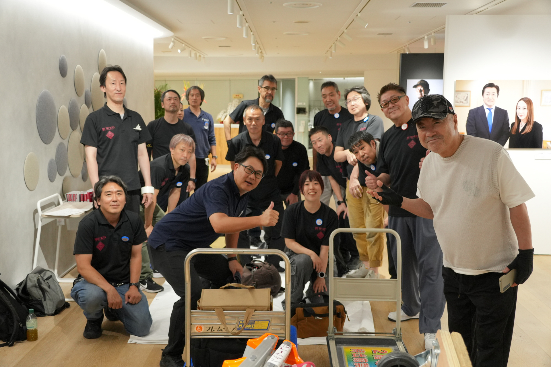 搬入終了後に奈須田社長、17名のフレームマンのスタッフ、写真弘社の川口さんと。おかげでいい展示会場ができた