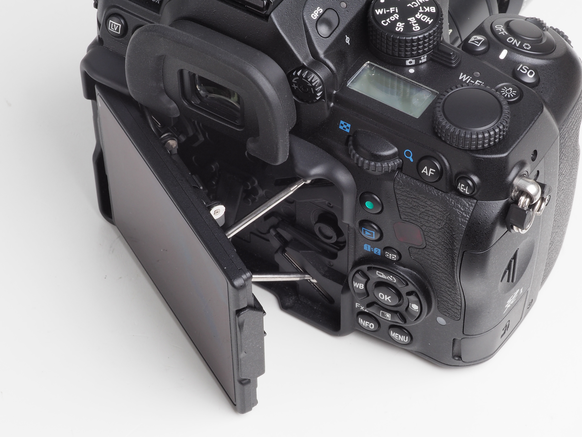 フレキシブルチルト式モニターという呼び名の背面LCDです。蜘蛛の足みたいな4本のステーがあり、いろいろな角度で設定できますね。これでライブビューの性能がもう少し高いのなら、役立つと思うのですが。右にあるのがグリーンボタンです。