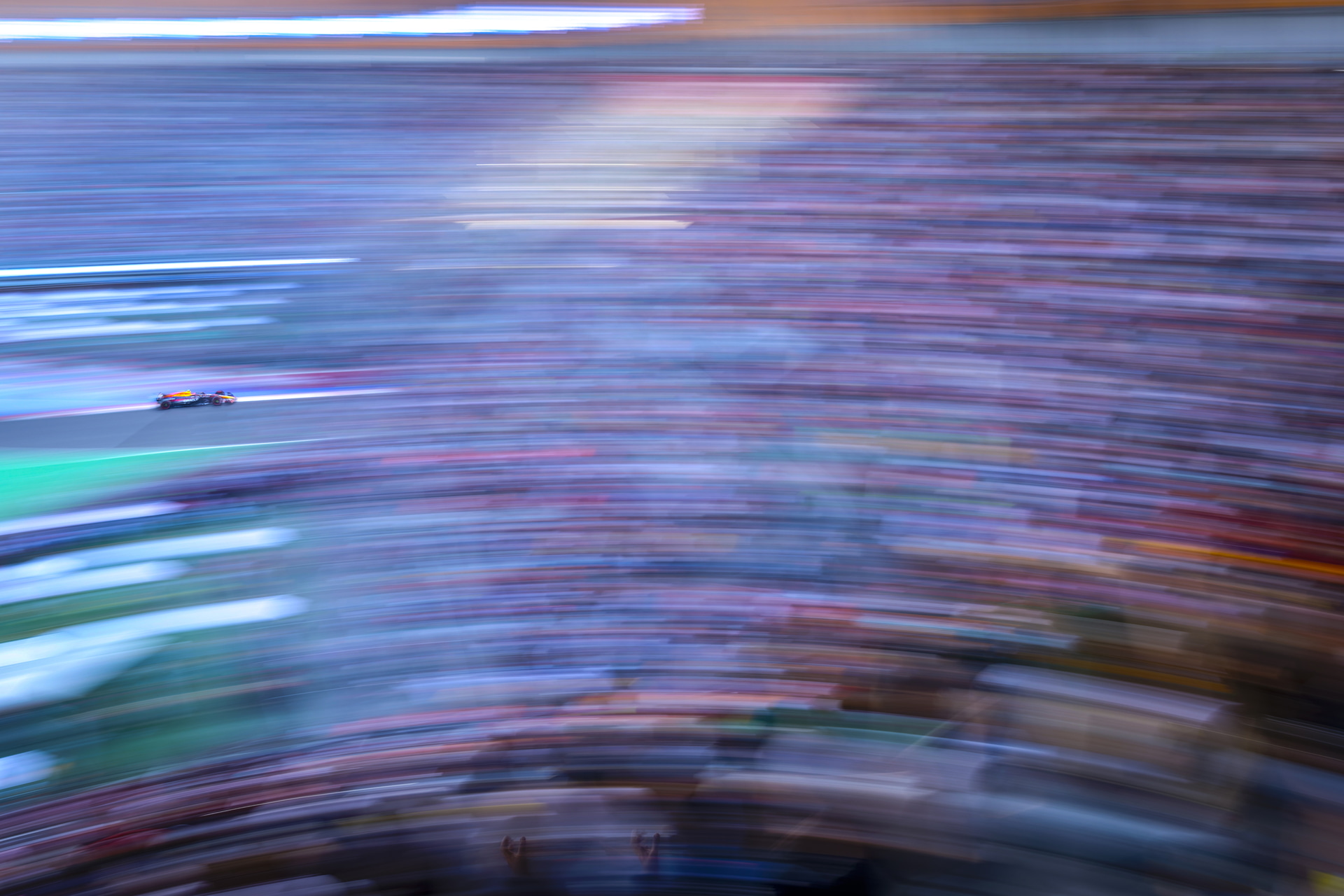 メキシコGPのセルジオ・ペレス選手。観客席の上から超スローシャッターを使い、満員の観客を流し撮りした。EOS R1はファインダーが大きく明るいため、マシンが小さくても逃さず捉えられる<br><span class="fnt-85">キヤノン EOS R1／RF35mm F1.4 L VCM／35mm／マニュアル露出（F16、1/2秒）／ISO 50／WB：太陽光</span>