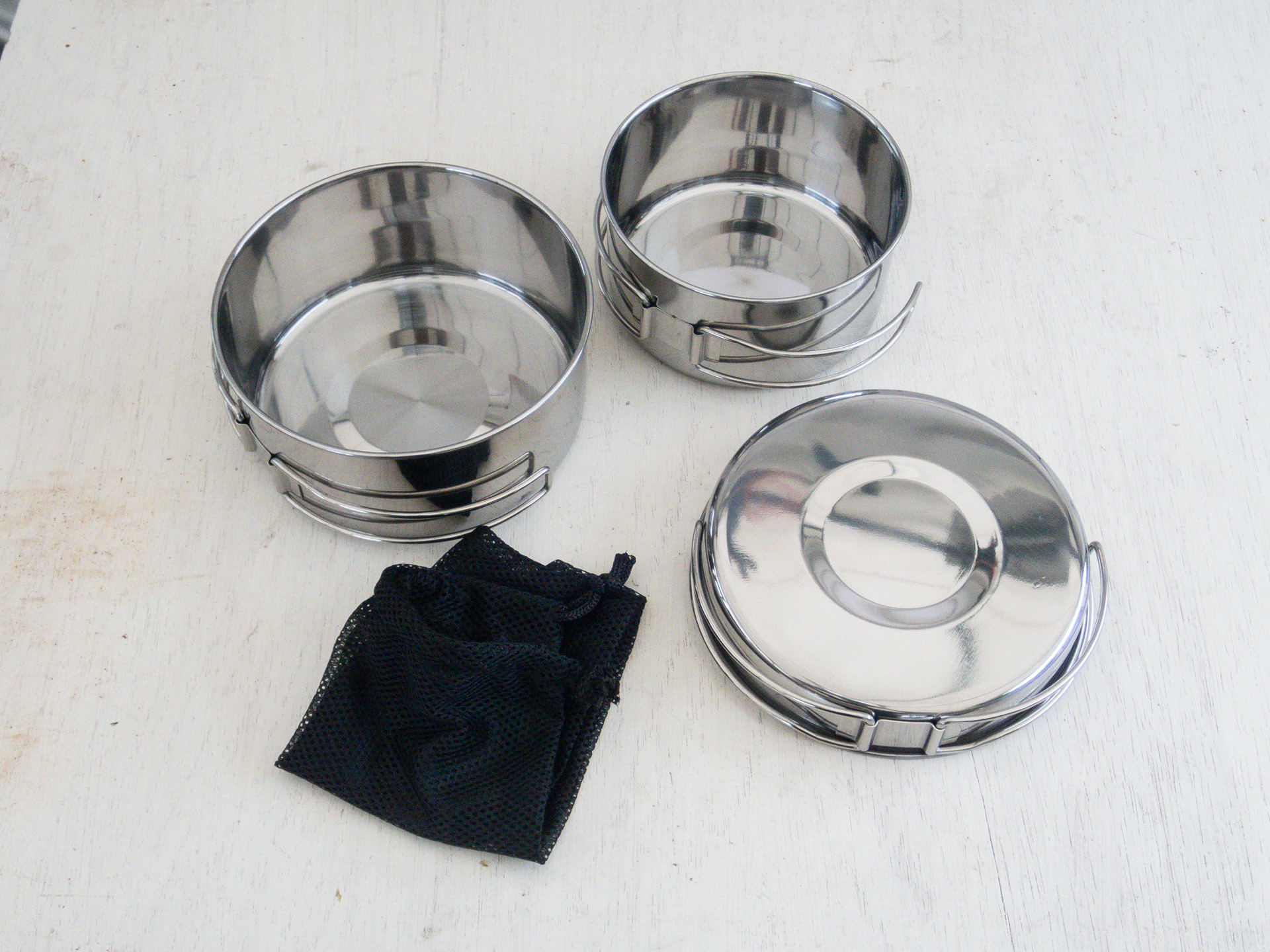 「<a href="https://jp.daisonet.com/products/4550480203652">クッカー3点セット</a>」ステンレス製。大小2つの鍋と蓋ひとつ、収納袋。食器小は今回の使い方では不要となる。