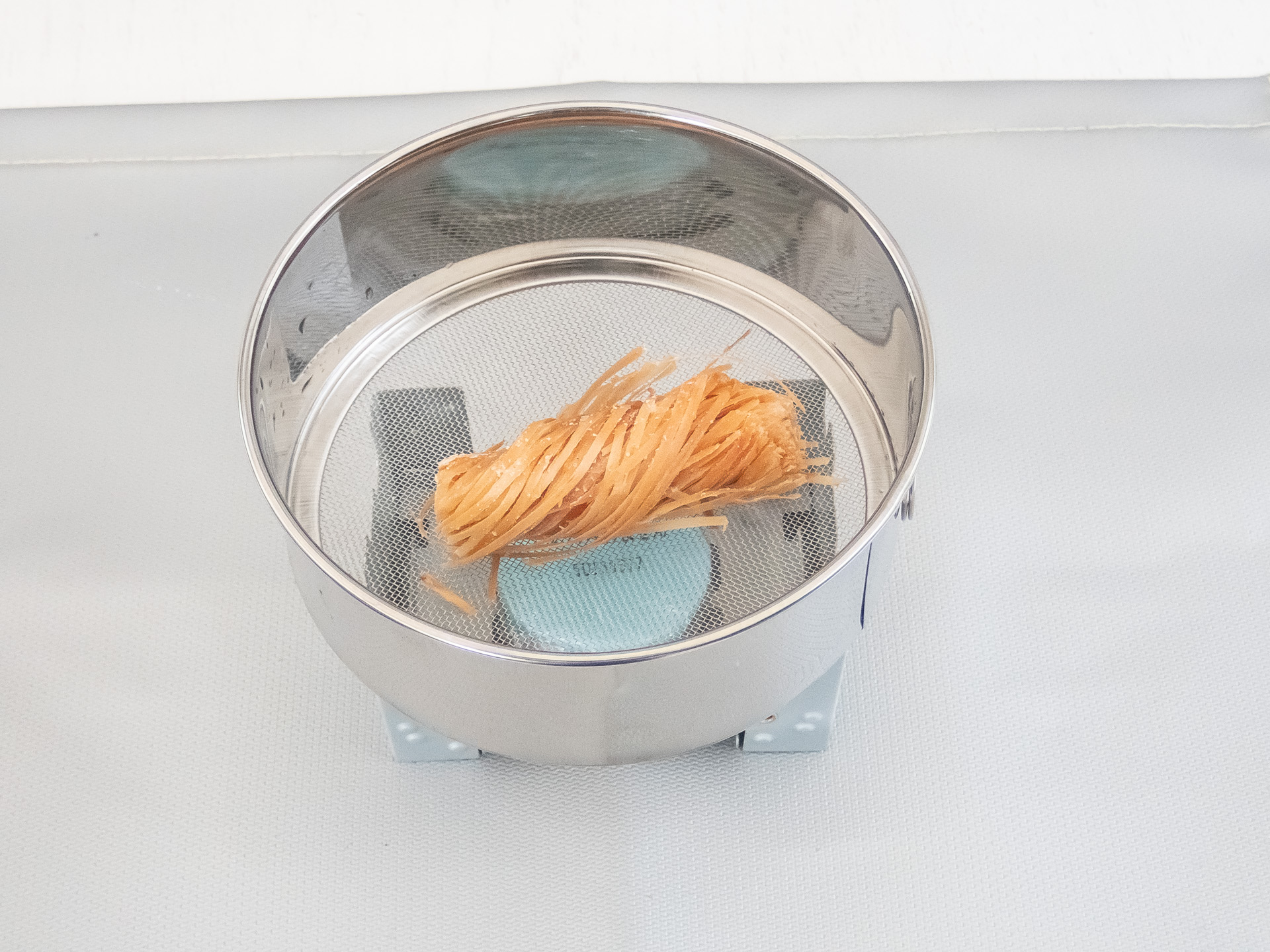 「ステンレス裏ごし」を置き、さらに着火剤を置く