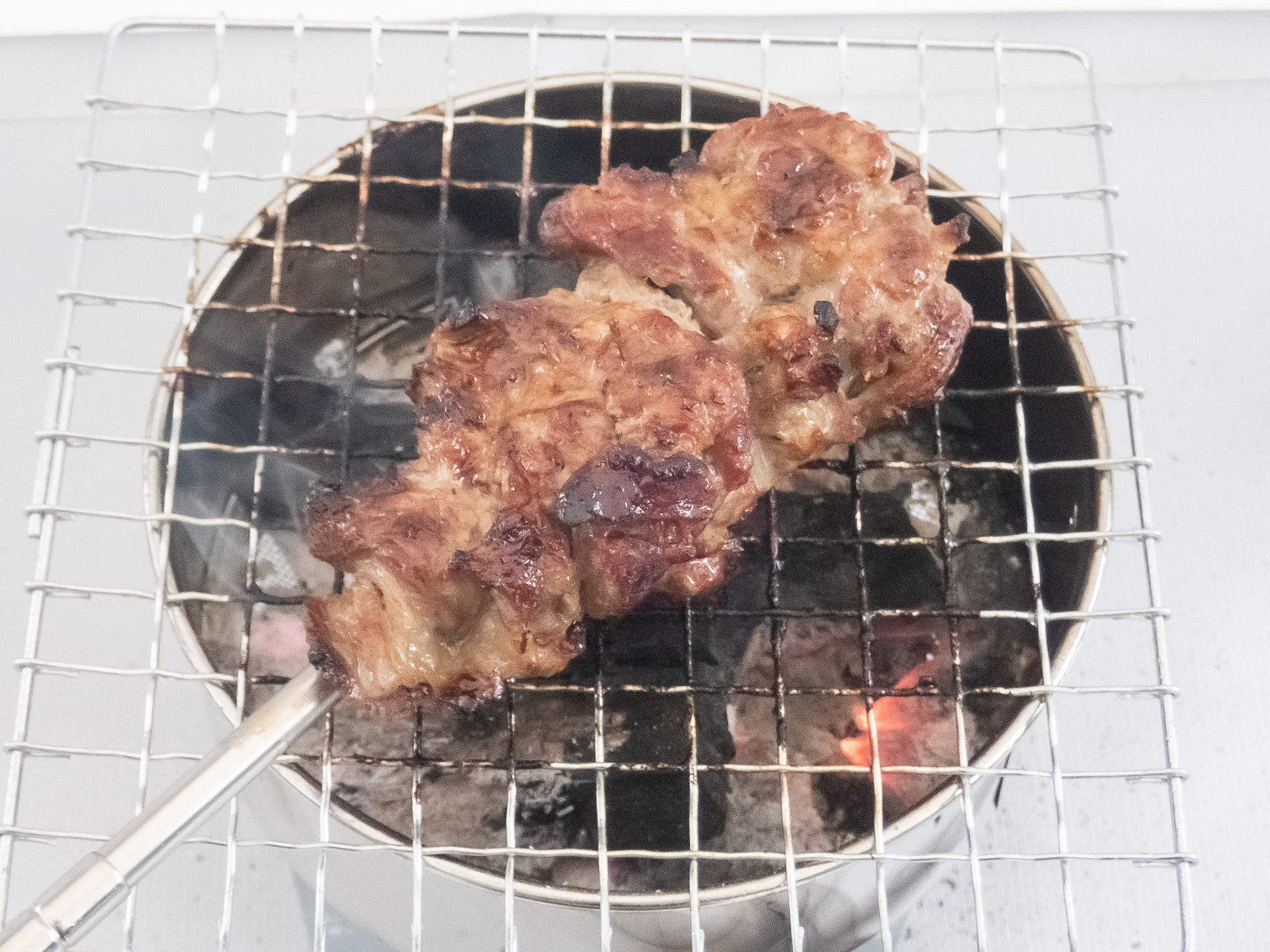 焼き網を置いて回しながらじっくりと焼く。落ちた脂の煙は当てないように