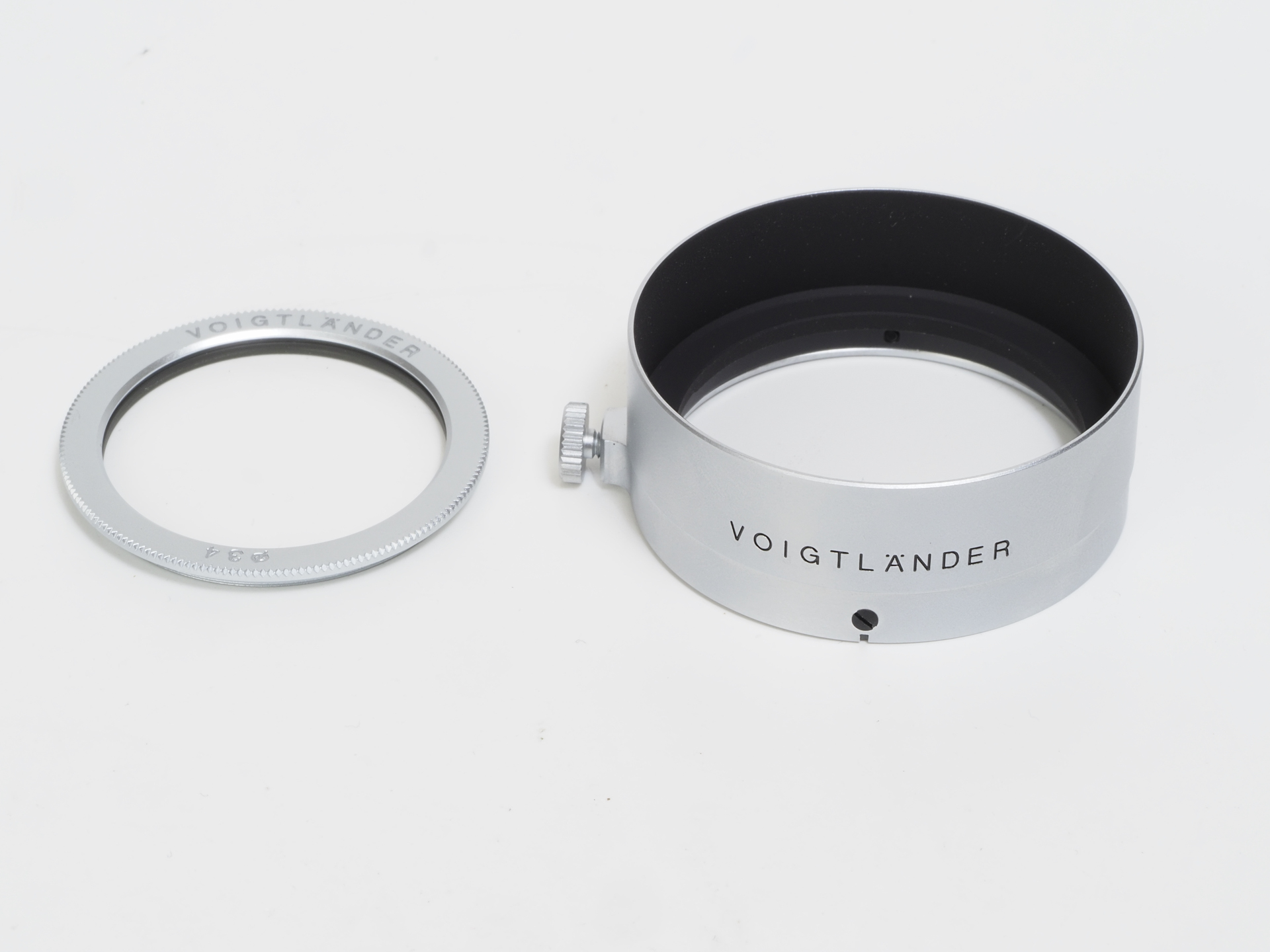 同梱のプロテクトフィルターとフード。フィルターはキヤノンレンジファインダー時代の交換レンズ用に似ているし、フードはElmar 3.5cm F3.5用のものに似ています。