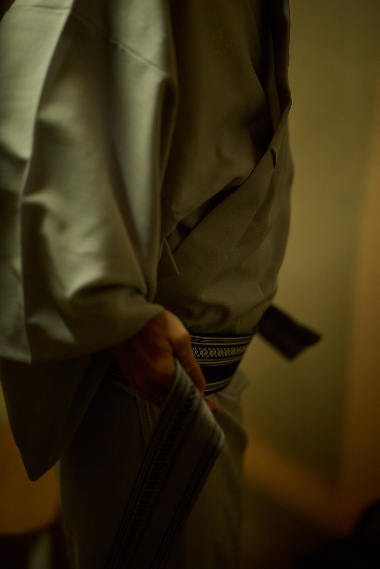 着物に着替える手元をクローズアップ。帯の美しい文様をほのかな明かりとたっぷりのボケで浮かび上がらせた。見せたい部分に視線を誘導させ、想像力を刺激する表現が得意なレンズだ<br><span class="fnt-85">キヤノン EOS R5 Mark II／85mm／マニュアル露出（F1.4、1/200秒）／ISO 800／WB：オート</span>