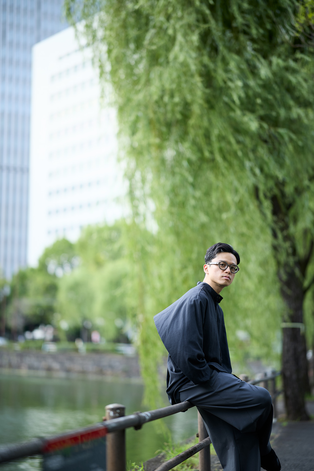 撮影を始めてからまだ時間が経っていない頃の写真。2人で歩きながら見つけた柵に腰を掛けてもらう。引きの距離で狙っていることもあるが、リラックスしたオフの時間を切り取った<br><span class="fnt-85">キヤノン EOS R5 Mark II／85mm／マニュアル露出（F1.4、1/1,000秒）／ISO 200／WB：5,200K</span>