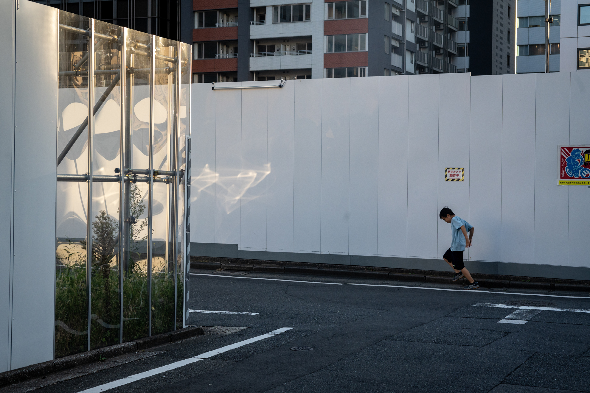 60mmですが標準レンズのつもりで街をスナップしてみました。反射した光が綺麗だと思って撮影したら、子供が飛び込んできました。ハイライトからシャドー部までよく繋がっています。<br><span class="fnt-85">ニコン Z5II／AF Micro NIKKOR 60mm F2.8 D（LA-FZ1を使用）／60mm／プログラムAE（1/800秒、F7.1、−0.7EV）／ISO 800</span>