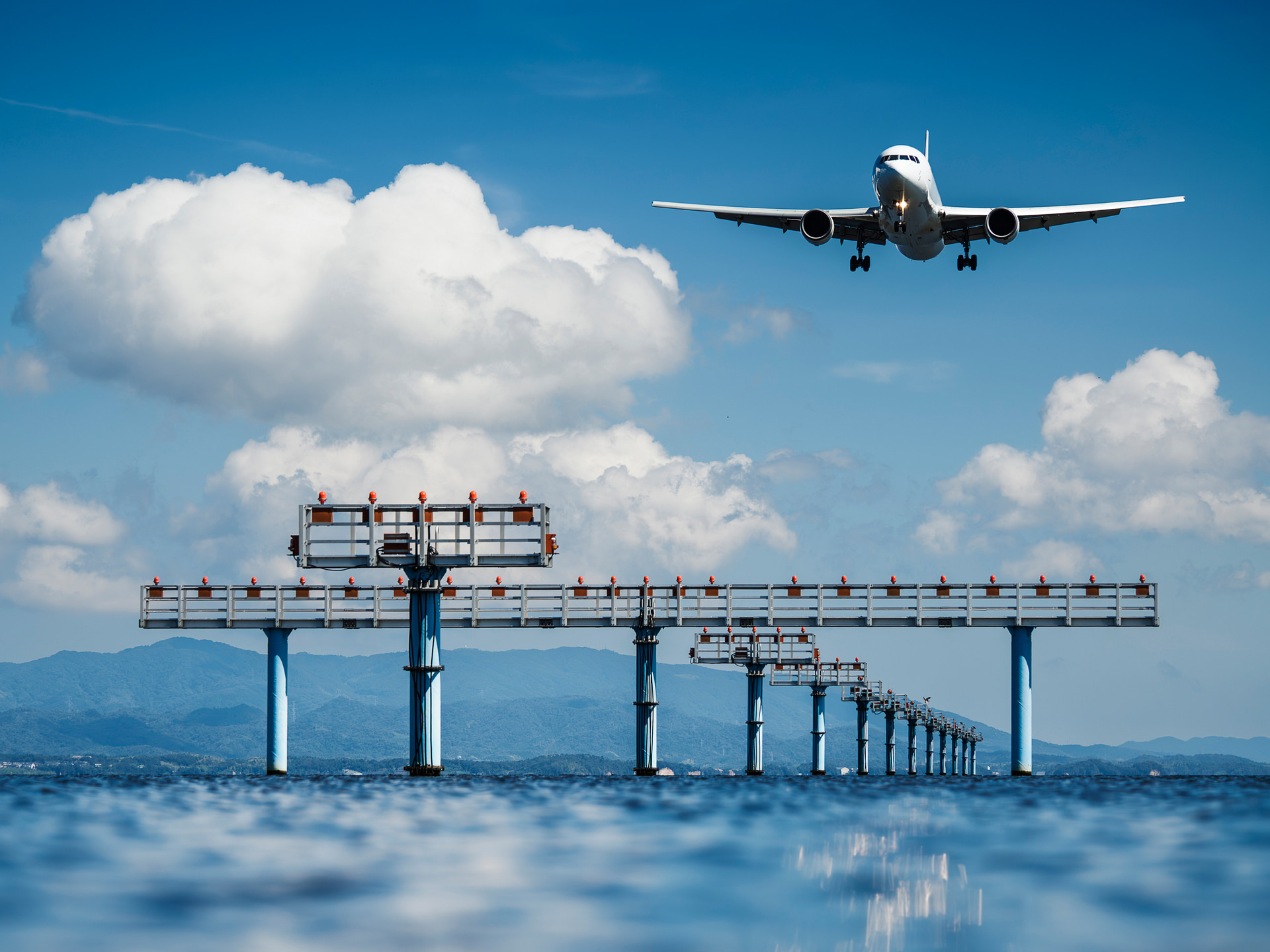 晴天の出雲空港。日の光を受け、まるで宝石のようにきらめく湖面を、開放F2.8の描写力を生かして繊細なボケとして取り込む。柔らかなボケ味と精緻な描写が見事に調和し、理想的な結果を生み出した<br><span class="fnt-85">OM SYSTEM OM-1 Mark II／73mm（146mm相当）／マニュアル露出（F2.8、1/2,500秒）／ISO 80／WB：オート／出雲空港</span>