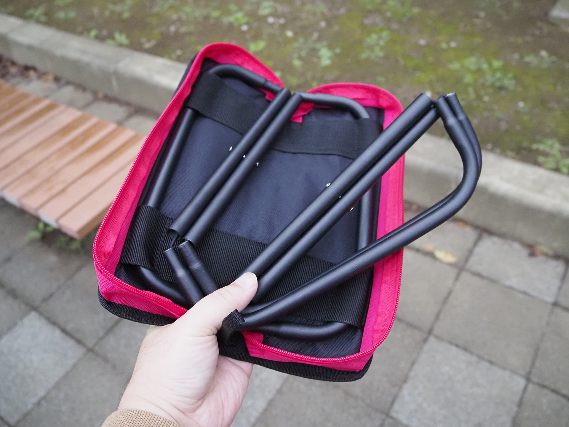 ケースが座面になる構造。パイプ内部にゴムひもが入っており、引っ張ってねじることで収納できるようになる