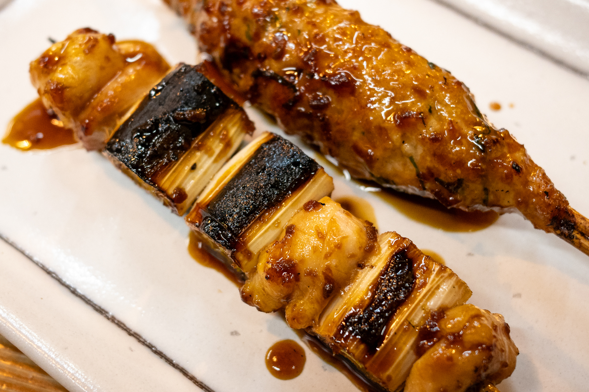 クロップして焼き鳥を撮りました。もちろん問題ない画質です。撮影者は酔眼ですから構図のバランスが崩れております。でもきちんと写るのはGR IVが優秀だからです（笑）。<br>リコー GR IV／絞り優先AE（1/60秒、F3.2、±0.0EV）／ISO 800／50mm相当にクロップ