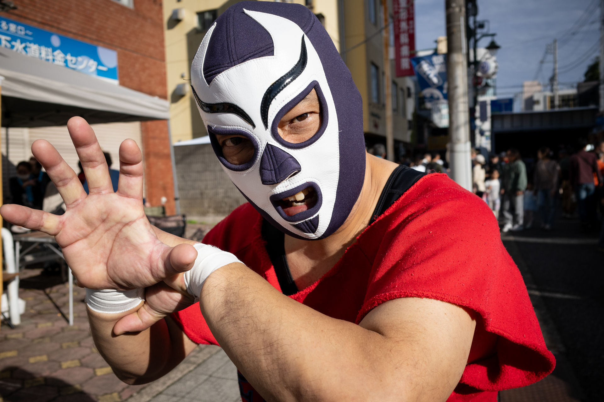 街中でレスラーと会いました。お願いして撮影させてもらいました。さすがにマスクにより顔認識は難しいようでしたが、問題なく手前の目に合焦しています。<br>リコー GR IV／絞り優先AE（1/2,500秒、F4.5、±0.0EV）／ISO 400