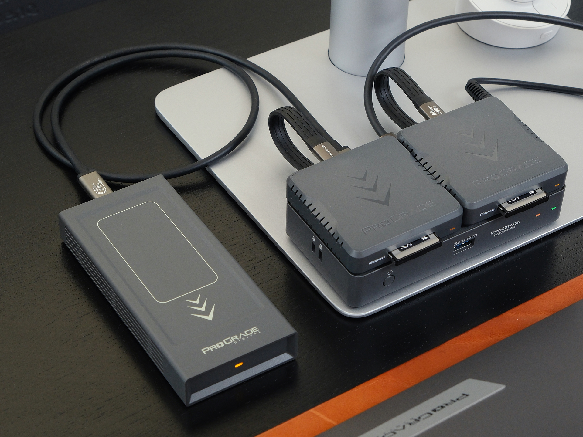 「PG20 Pro Thunderbolt 4 Hub」（右下）を活用して、デスク周りを整理した。マグネットベースによりProGrade Digital製カードリーダーや外付けSSDをスマートに連結できるのもポイントだ。PG10 Pro（左）と同じサイズのため、この2つを重ねることも可能