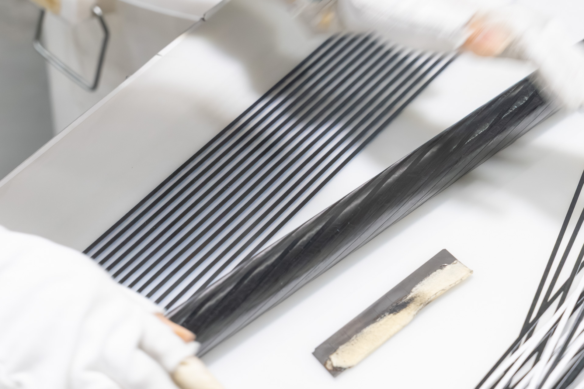 その台紙の上で金型を転がして斜めにカーボンシートを貼り付ける