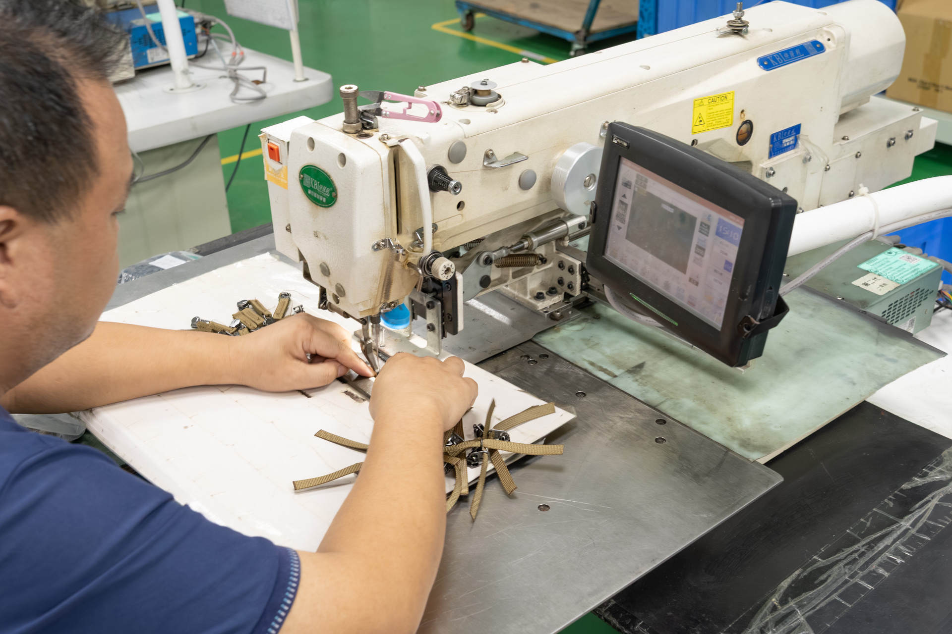 ファスナーのタブも手作業で縫い付けている