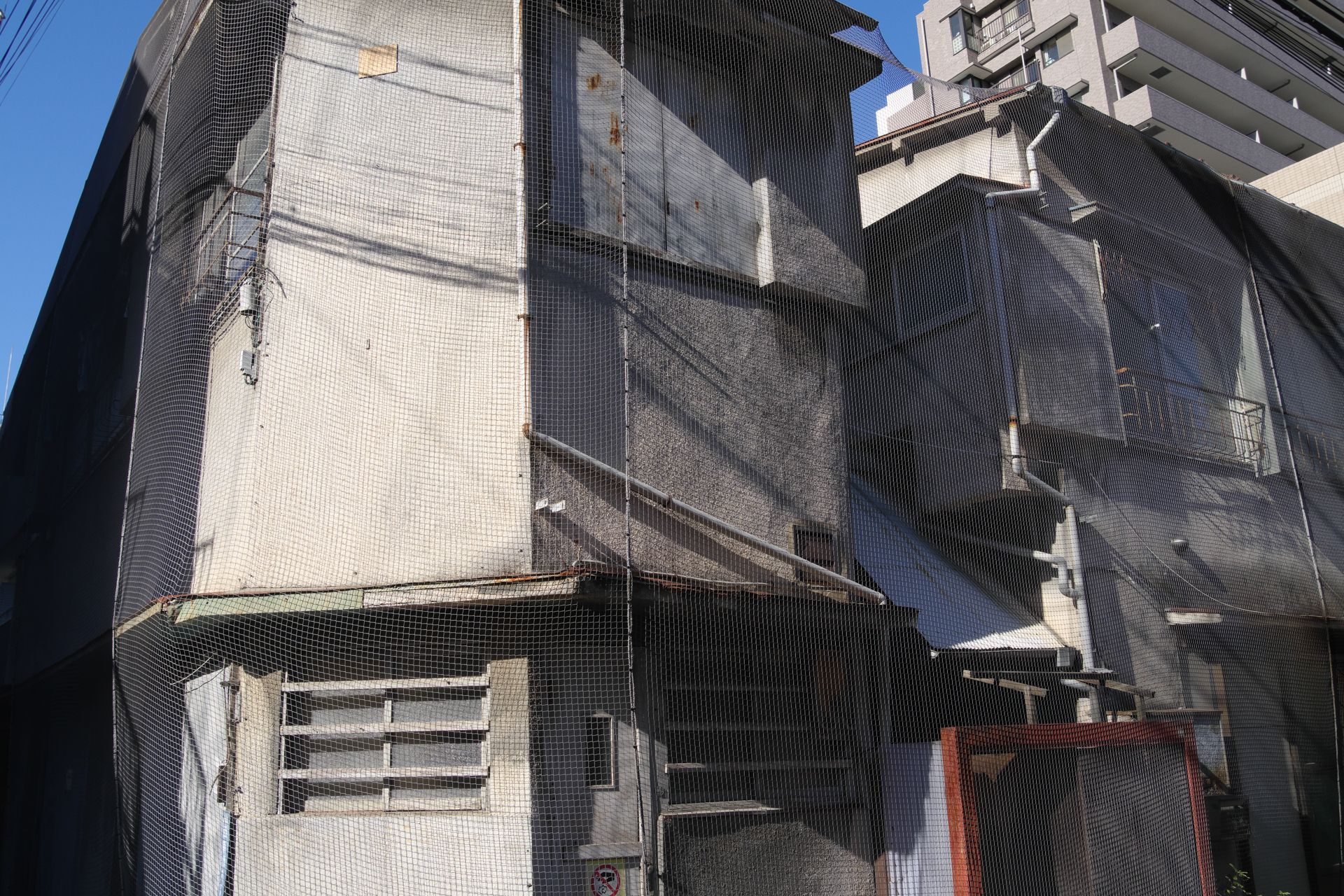 取り壊されるアパート。今月のスクラップアンドビルド。取り壊しも建築も二度と撮れないということでは一致しているので、必ずこうした光景は残します。<br><span class="fnt-85">PENTAX K-3 Mark III／HD PENTAX-DA 20-40mmF2.8-4ED Limited DC WR／20mm（30mm相当）／絞り優先AE（1/500秒、F9.0、−0.7EV）／ISO 400</span>