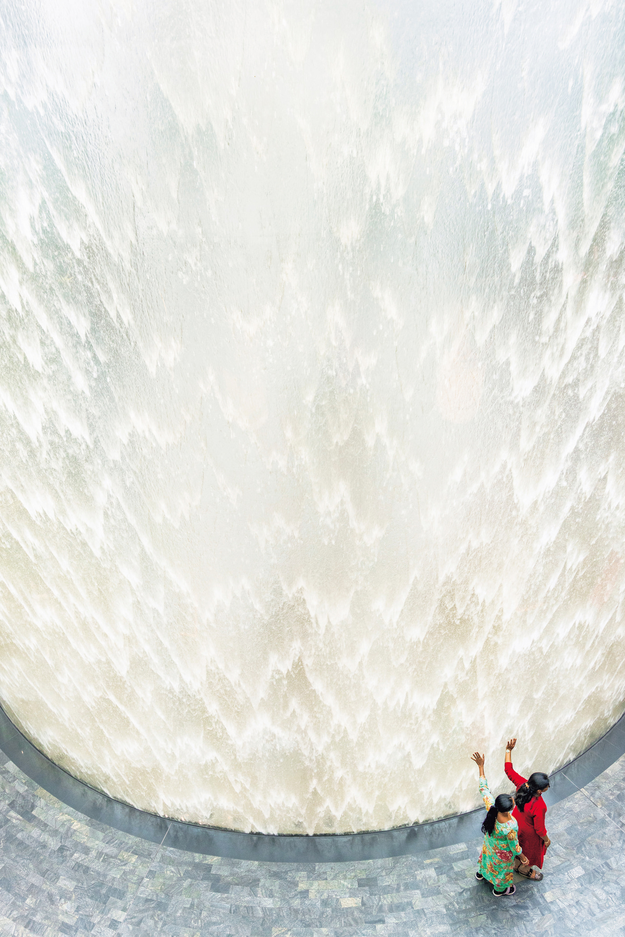 チャンギ国際空港の中にある滝。ガラスの中を流れ落ちるのだが、そこに手を当てる人物を入れて広角レンズで切り取るとダイナミックで不思議な写真に仕上がった<br><span class="fnt-85">キヤノン EOS R6 Mark III／RF24-105mm F4 L IS USM／27mm／マニュアル露出（F5、1/160秒）／ISO 1600／WB：オート</span>