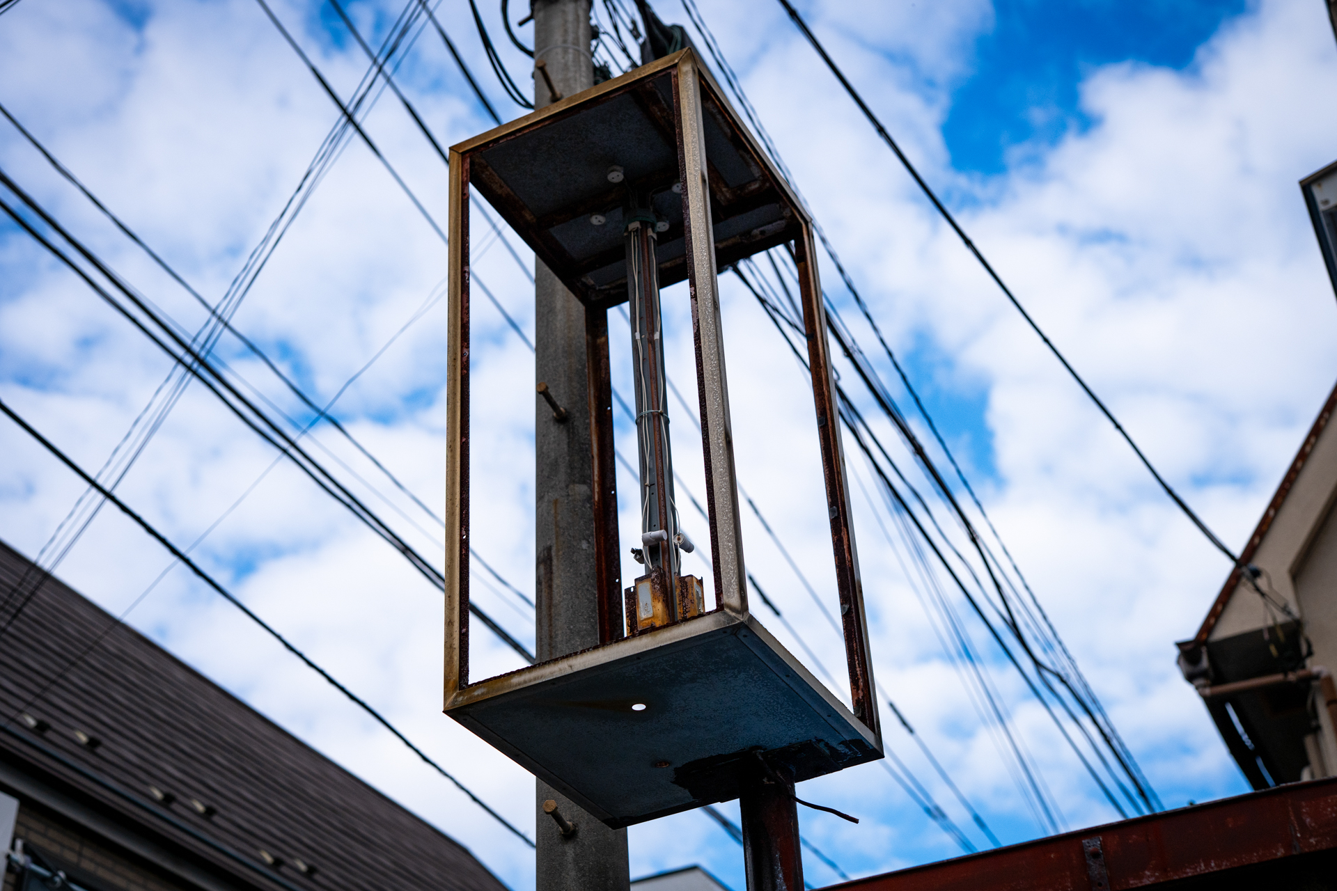 もとはアクリルかガラスがハマっていた看板でしょうが、ホネだけが残って、珍妙な状況になっています。<br><span class="fnt-85">LUMIX S5IIX／SIGMA 50mm F1.4 DG HSM｜Art／プログラムAE（1/6,400秒、F3.2、−0.3EV）／ISO 400</span>