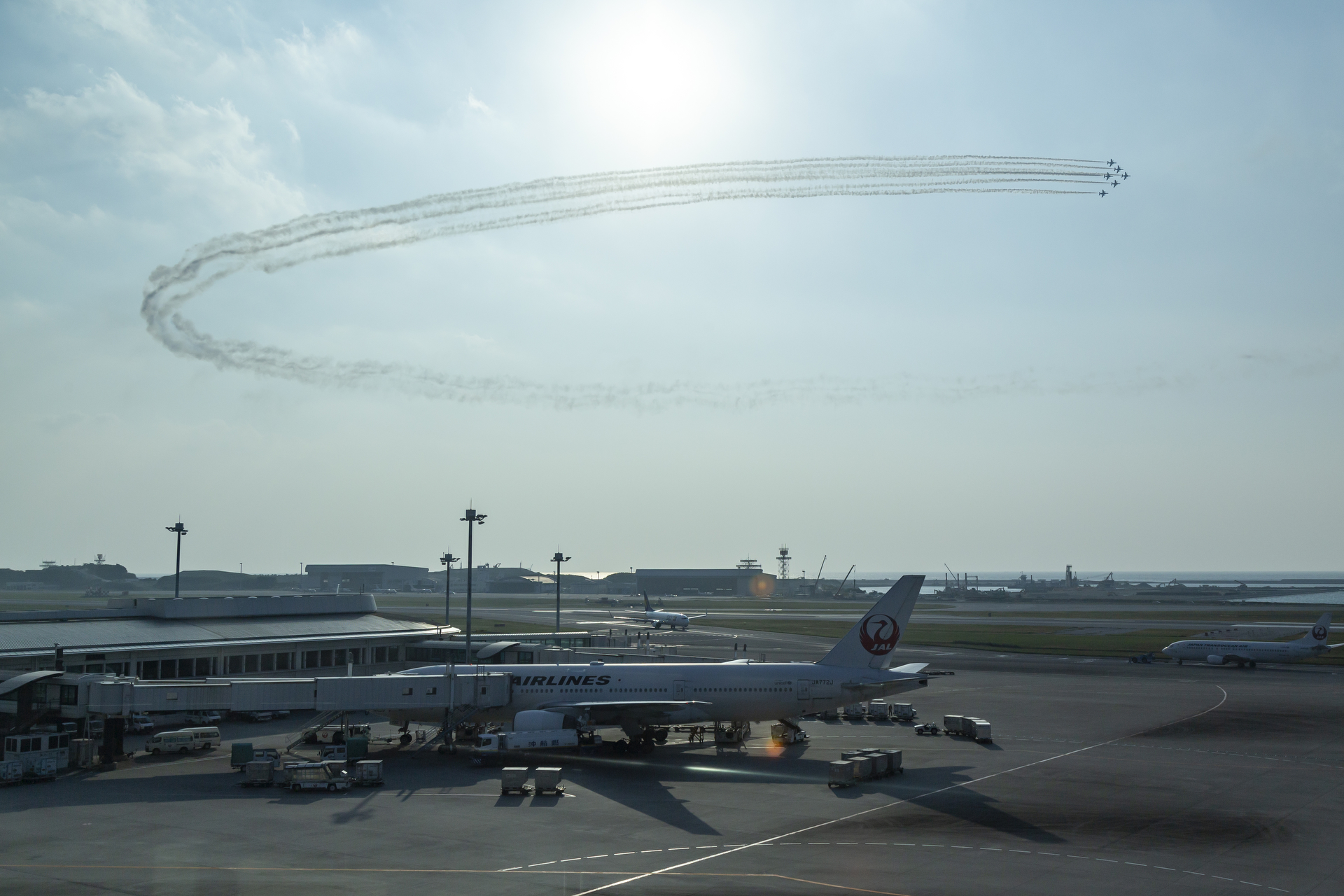 那覇空港のターミナルビルの窓越しにも見ることができるブルーインパルスの展示飛行（2016年の美ら島エアフェスタにて撮影）<br>キヤノン EOS 6D／EF24-105mm f/4L IS USM／32mm／絞り優先AE（1/4,000秒、F8）／ISO 250