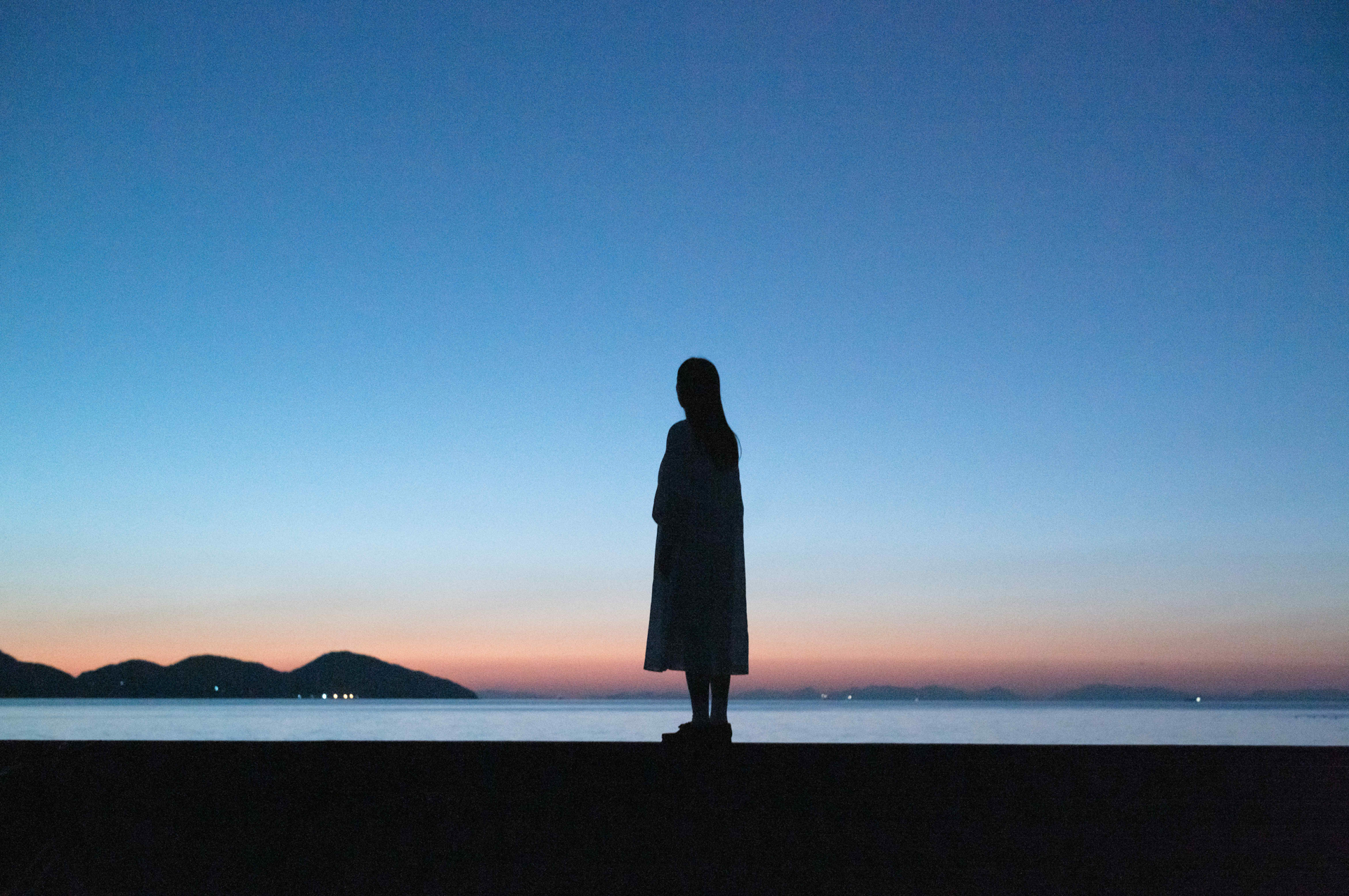 夕暮れの防波堤で静かに海を見つめると穏やかな瀬戸内海の島々と、澄んだ空が広がっていた。ライカM EV1は世界が動き始める時間、世界が静まっていく時間のグラデーションを表現するのにぴったりだ<br><span class="fnt-85">ライカM EV1／ライカ ズミルックスM f1.4/50mm ASPH.／50mm／マニュアル露出（F4.8、 1/90秒）／ ISO 4000／ WB：白熱灯</span>
