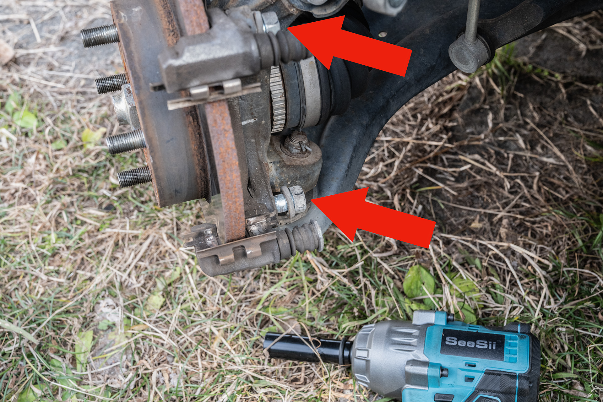 キャリパーホルダーを外すには赤矢印のボルト2本を外す。強く締め付けられているのでインパクトレンチがあると楽