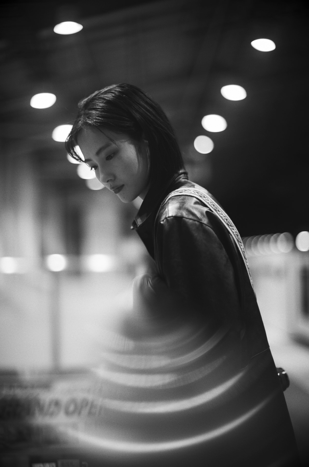 駅の階段にある銀色の丸い手すりにカメラを乗せて撮影した。天井の照明が金属に反射し、画面下部に独特の丸いボケが生まれる。明るいレンズを開放で使い、この不思議な描写を作り出している<br><span class="fnt-85">Leica Camera ライカM10モノクローム／ノクティルックスM f0.95/50 ASPH.／50mm／マニュアル露出（F0.95、1/60秒）／ISO 1600</span>