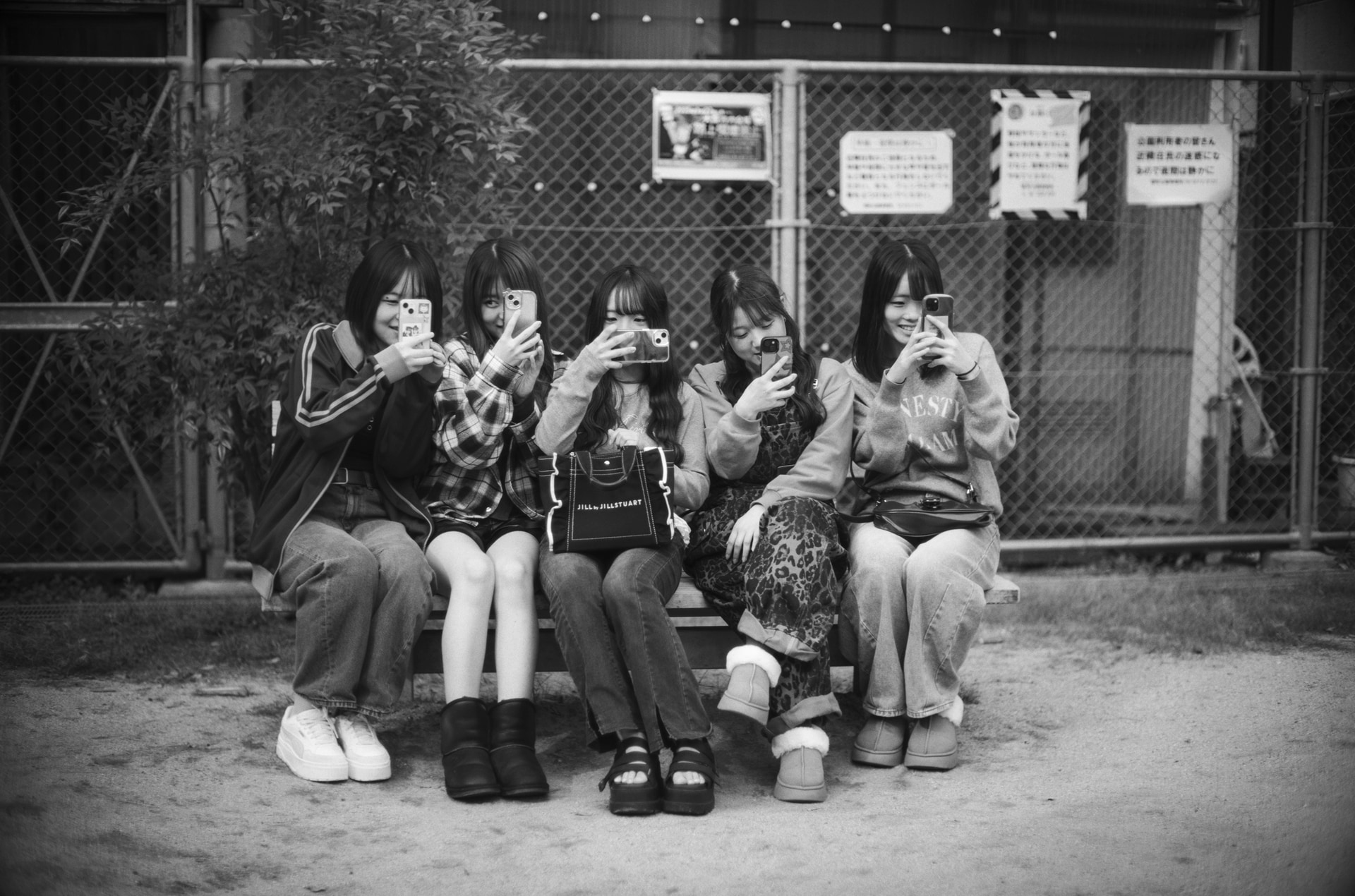 大阪・梅田の近くにある中崎町の路地を歩いているとき、小さな公園のベンチに5人の女の子が座っているのを見かけた。彼女たちは新潟から来た看護学生さんたちで「写真を撮らせてください」と声をかけると同時に、「僕のこともスマホで撮ってよ」なんて会話をしながら、お互いに撮り合うような形で撮影した<br><span class="fnt-85">Leica Camera ライカM10モノクローム／ノクティルックスM f0.95/50 ASPH.／50mm／マニュアル露出（F0.95、1/180秒）／ISO 160</span>
