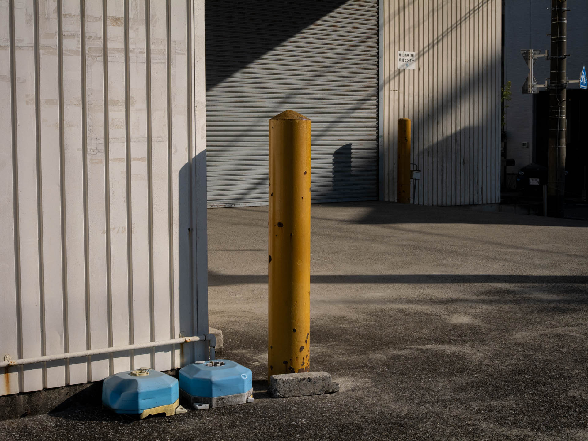 車からガードするポールだって、光の当たり方では存在感を示すわけであります。パンフォーカスになってしまいました。<br><span class="fnt-85">LUMIX G9PROII／SIGMA 30mm F2.8 EX DN／30mm（60mm相当）／プログラムAE（1/2,000秒、F9.0、−0.7EV）／ISO 400</span>