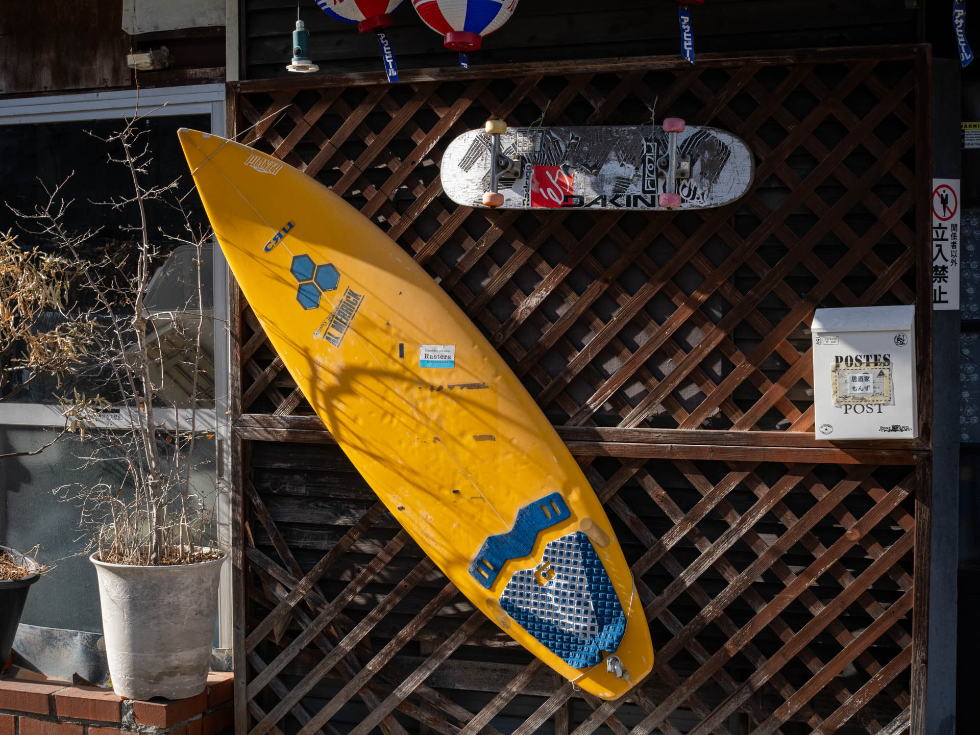 居酒屋の店頭ですね。店主はサーファーなんでしょうか。色の感じは見た通りそのままの良い再現です。<br><span class="fnt-85">LUMIX G9PROII／SIGMA 30mm F2.8 EX DN／30mm（60mm相当）／プログラムAE（1/640秒、F6.3、−0.7EV）／ISO 400</span>