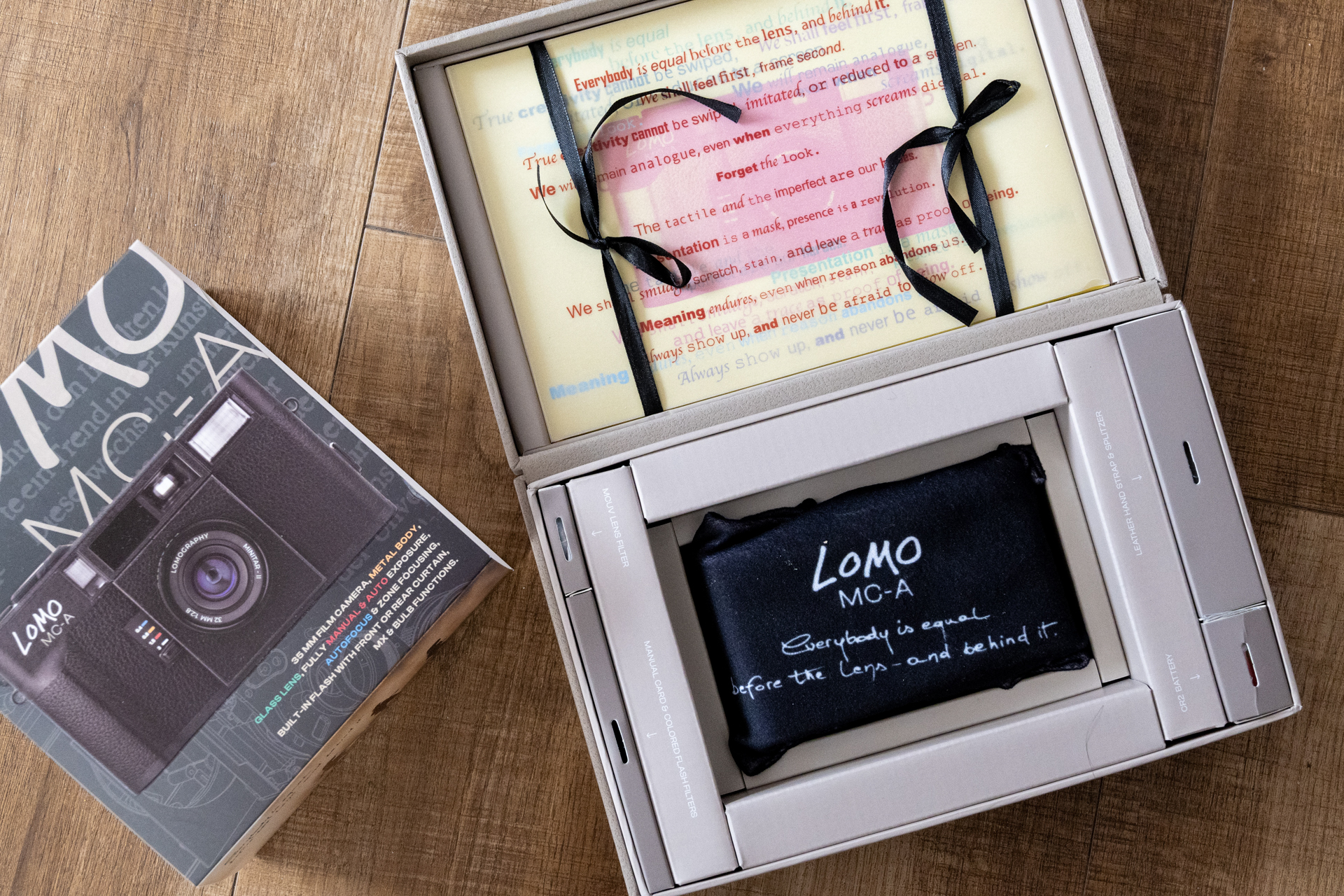 届いたMC-A元箱を開けてみます。クロスに包まれた本体、充電タイプのCR-2電池、フィルター、ストラップ、Lomoで撮影された厚い写真集が同梱されています。取り扱い説明書はQRで読み込む方式ですね。