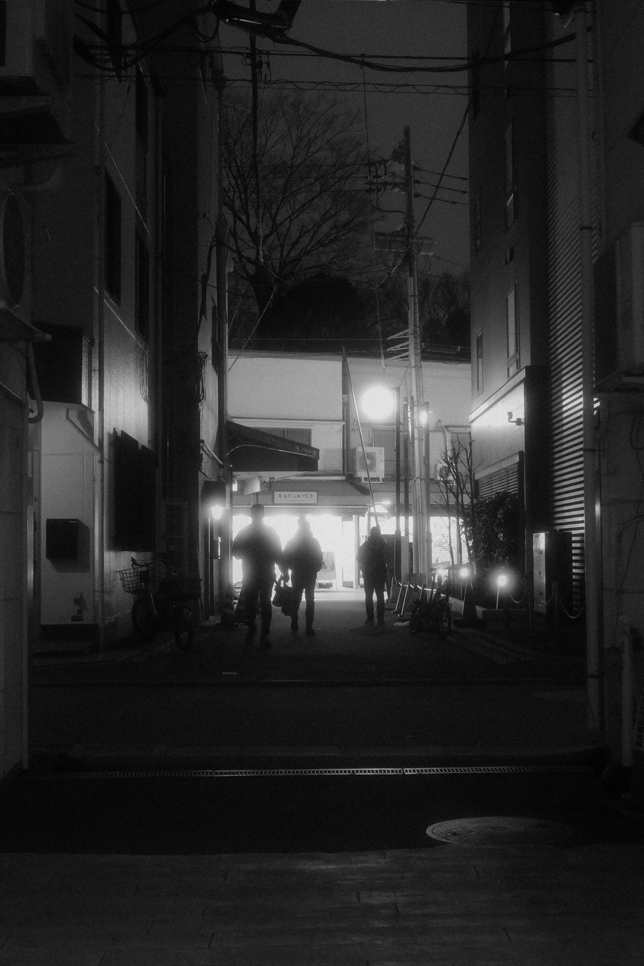 シルエットになった人物の輪郭が背後の照明によって幻想的だ<br><span class="fnt-85">GR IV HDF／18.3mm（クロップ50mm）／絞り優先AE（F4.5、1/30秒、＋0.3EV）／ISO 6400／WB：AWB／イメージコントロール：ソフトモノトーン</span>