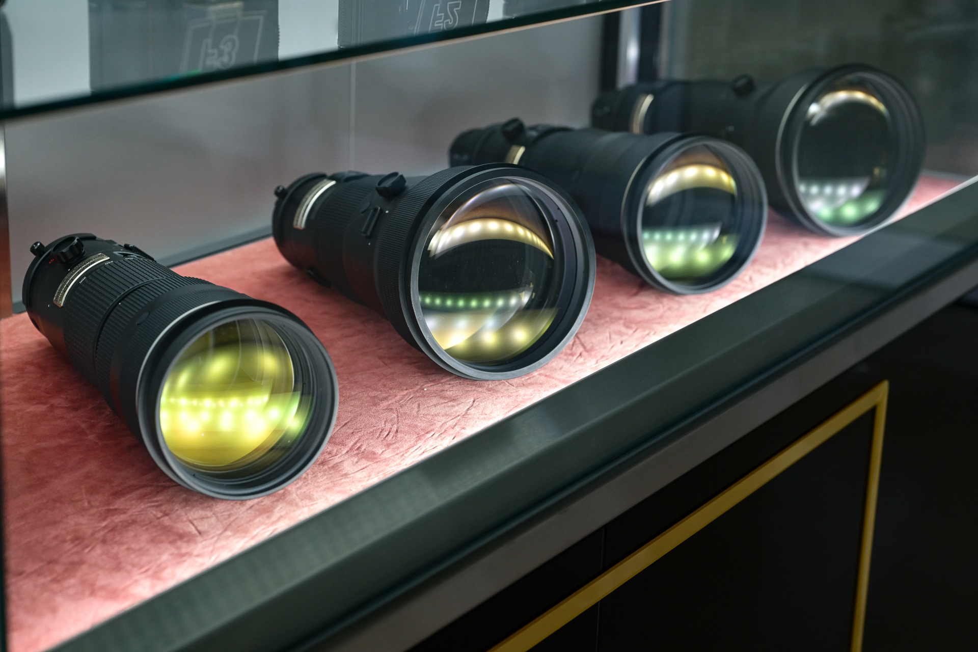 栃木ニコンが手がけたレンズ群。展示ケースのライティングが素晴らしく、Fレンズの特徴的な緑色のコーティング反射を引き立てている