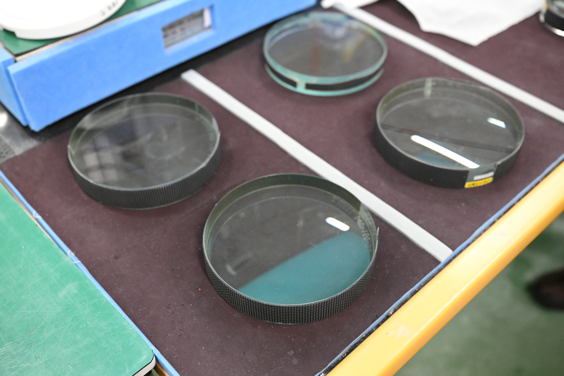 研磨したレンズと逆のカーブを持つ、比較測定用の「原器」と呼ばれるレンズ。重ねることにより発生する「干渉縞」（かんしょうじま。ニュートンリングとも）で曲率差をチェックする。規定に入っていないものは再度研磨する