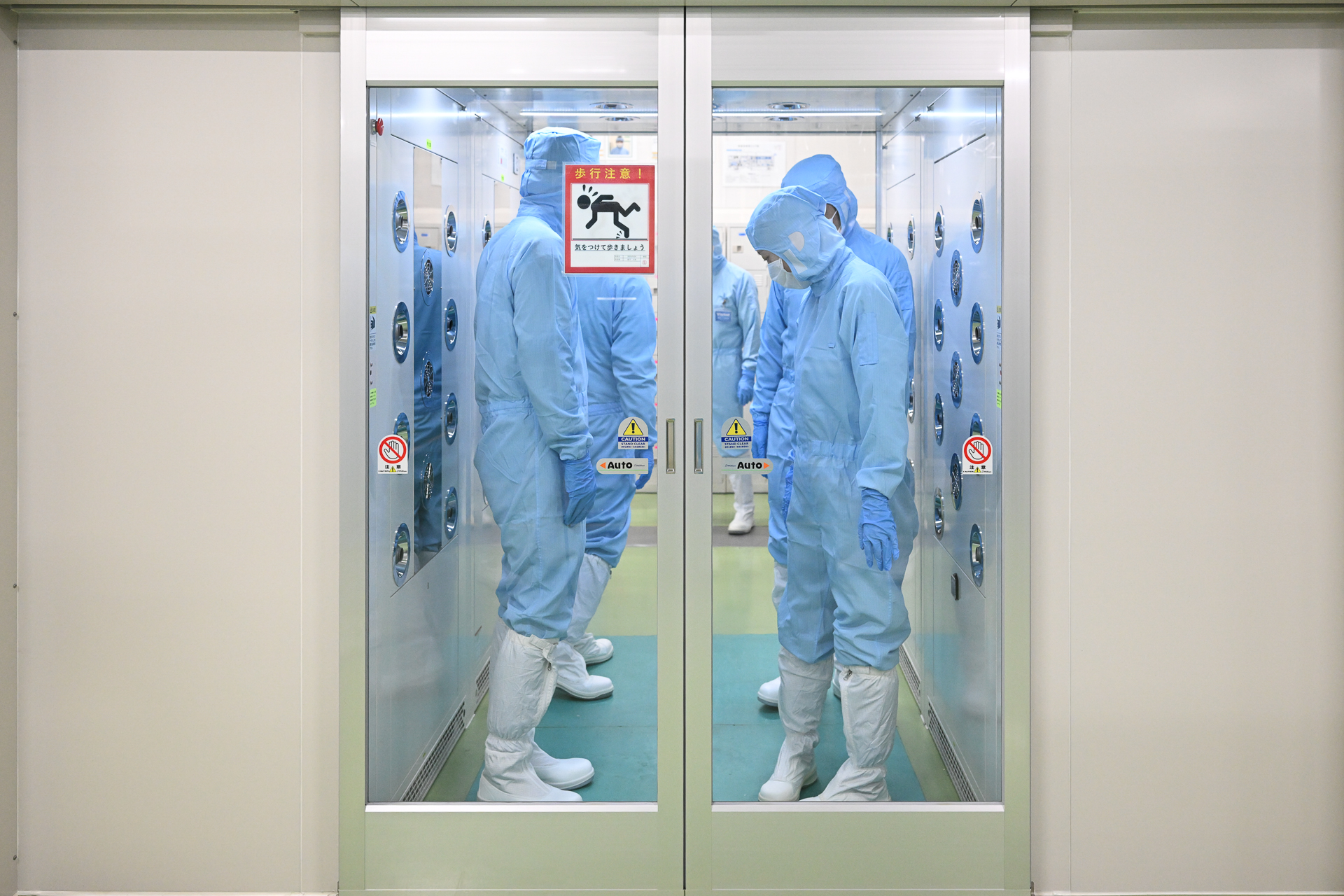 エアシャワーを浴びる。水色に染まった同行者の姿には、宇宙ミッションに飛び立つクルーかのような非日常感が漂う。宇宙クラスの精密光学機器を製造する場所には正装だ