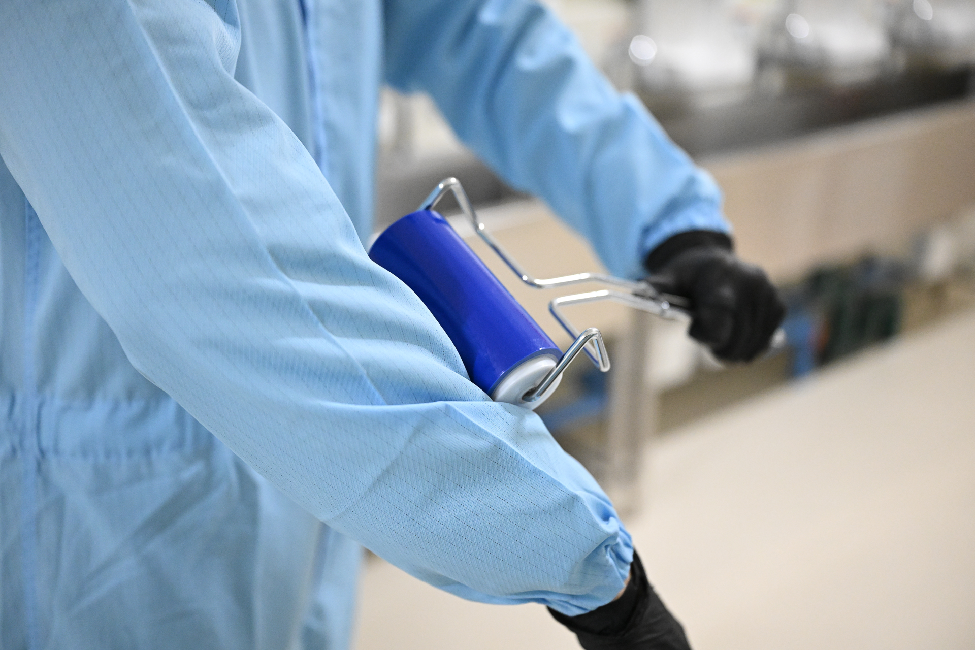 クリーンルーム立ち入り前にも、防塵服の上から除塵ローラーを体に掛けた。こうした“ゴミケバ”対策も年々レベルアップ