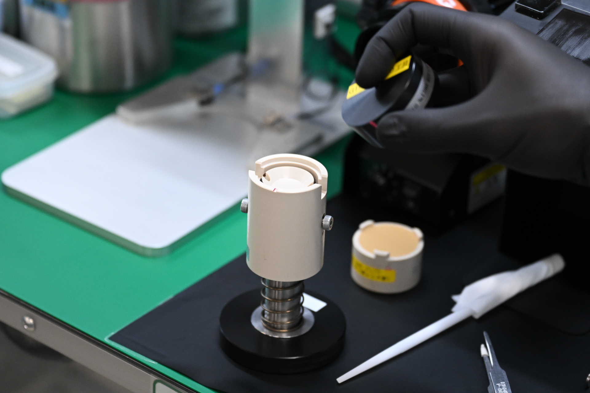 レンズ室にレンズをセットするための工具。上の窪みにレンズを載せる。それぞれの工程で外観検査も行うため、清掃用のスティックやホコリを飛ばすエアツールも備わっている