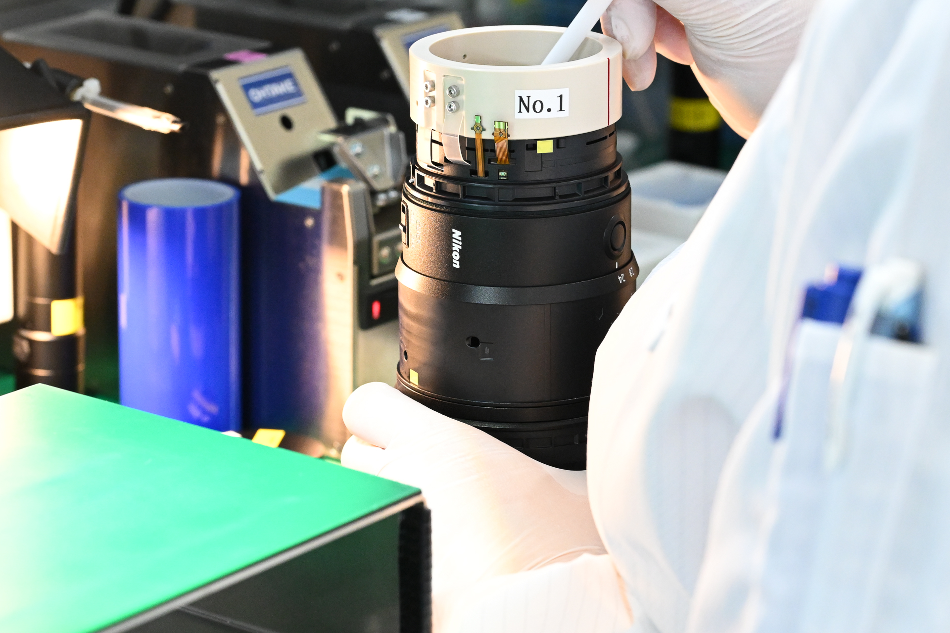 上から鏡筒の外装部分を取り付ける。左奥に見える青い筒は除塵ローラー。作業ごとに両手で“コロコロ”とやり、鏡筒内への異物混入を防ぐ