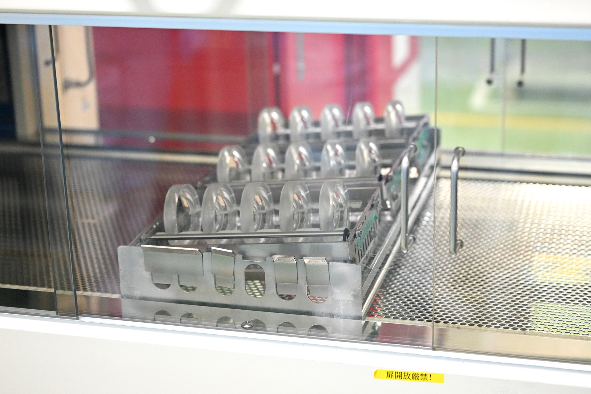 洗浄後のレンズは、装置外の空気に触れないようにレールを通り、清浄度の高いクリーンエリアへ直送されてくる