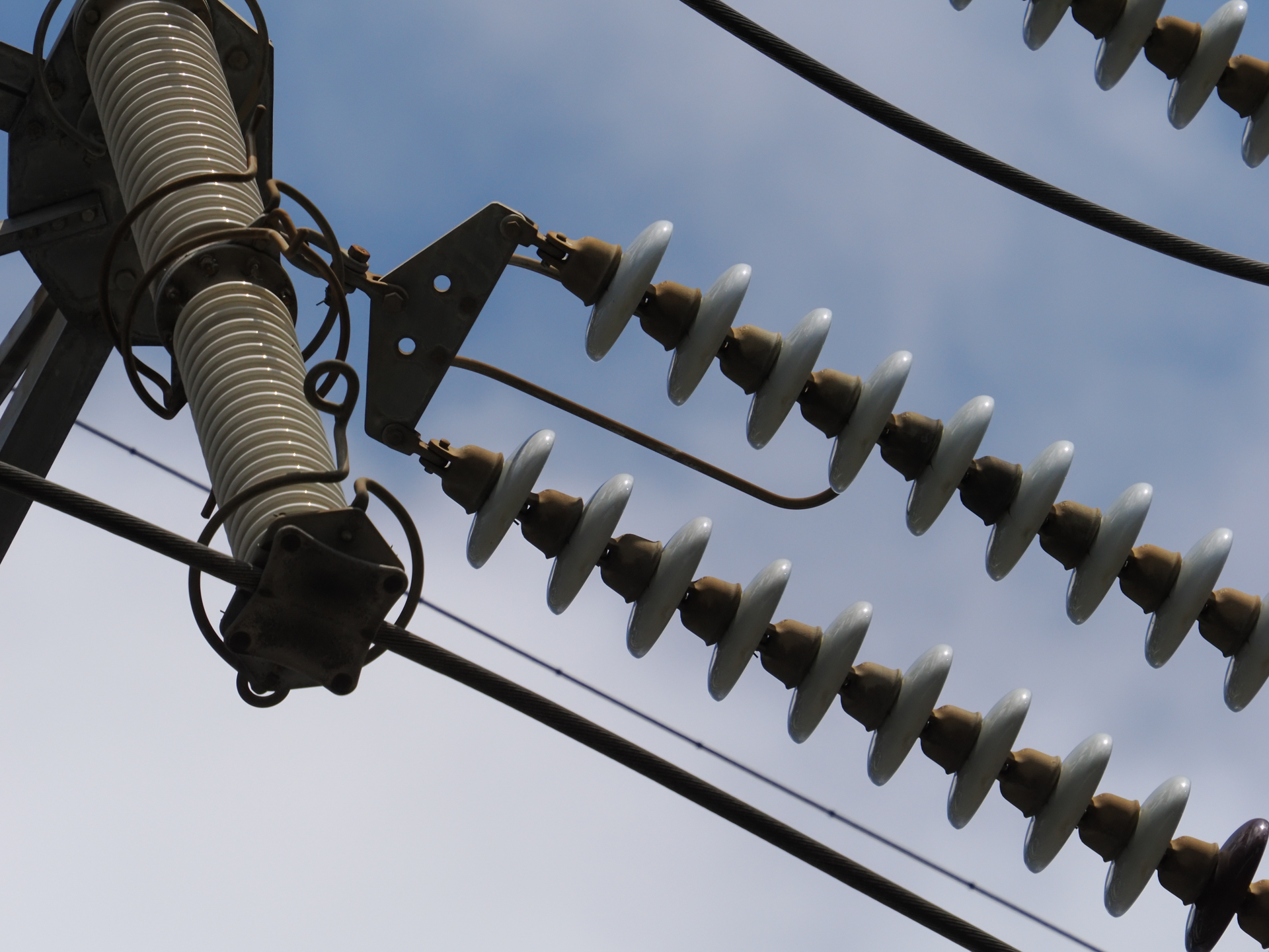 行儀良く並んでいる碍子なのですが、普段は意識することもありません。地上から空に向けて、部分を切り取るような印象です。<br><span class="fnt-85">OM SYSTEM OM-1／M.ZUIKO DIGITAL ED 50-200mm F2.8 IS PRO＋MC-20／400mm（800mm相当）／絞り優先AE（1/4,000秒、F8.0、−0.7EV）／ISO 800</span>