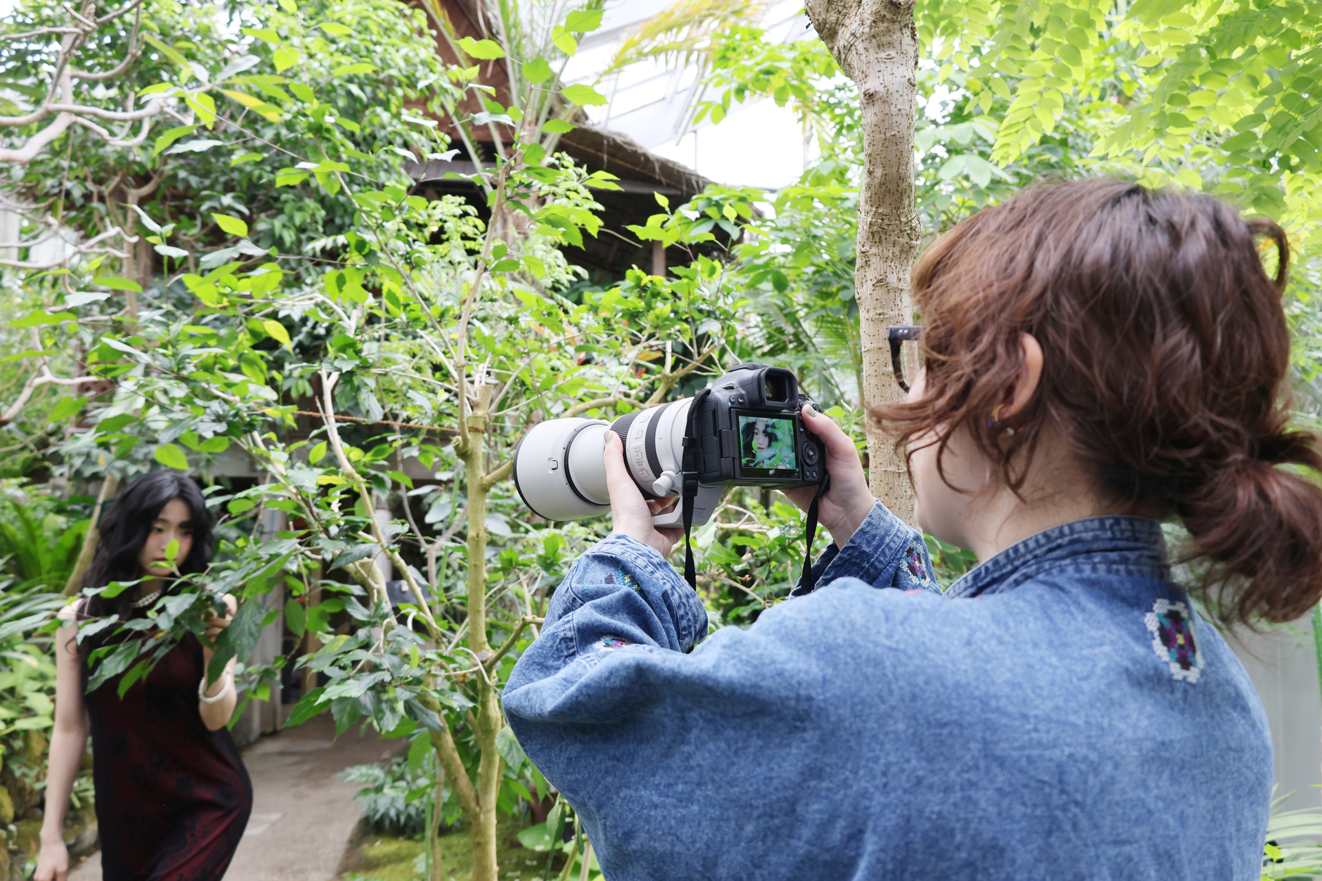頭上からは自然光、モデルの斜め前からは蛍光灯が当たるミックス光のシーンだった。加えて、緑の葉を通した光が肌に当たっていた