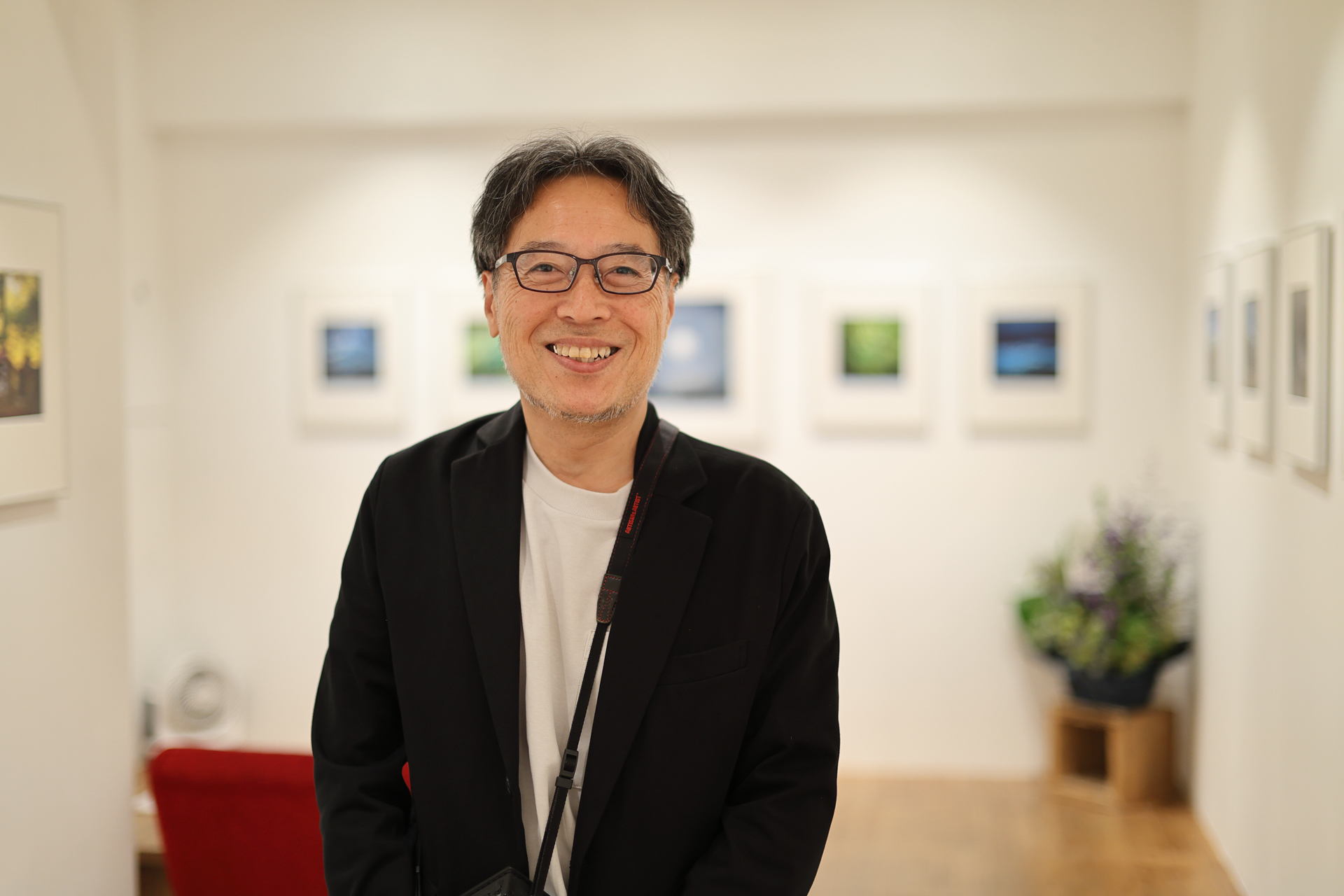 友人の写真家の小原孝博さん。開催中の写真展の会場で撮影させていただきました。アベイラブルライトフォトです。背景の額の縁とか、植物もクセがなく綺麗にボケます。完全なカメラ任せでの撮影ですが作者の思惑以上の仕事をしてくれたりします。<br><span class="fnt-85">キヤノン EOS R6 Mark II／RF45mm F1.2 STM／45mm／絞り優先AE（1/250秒、F1.2、0EV）／ISO 400</span><br>　<br><a href="https://www.roonee.jp/exhibition/room1-2/20260505183232">小原孝博 写真展「鳴動」</a><br><span class="fnt-90">Roonee 247 fine arts・6月14日（日）まで</span>