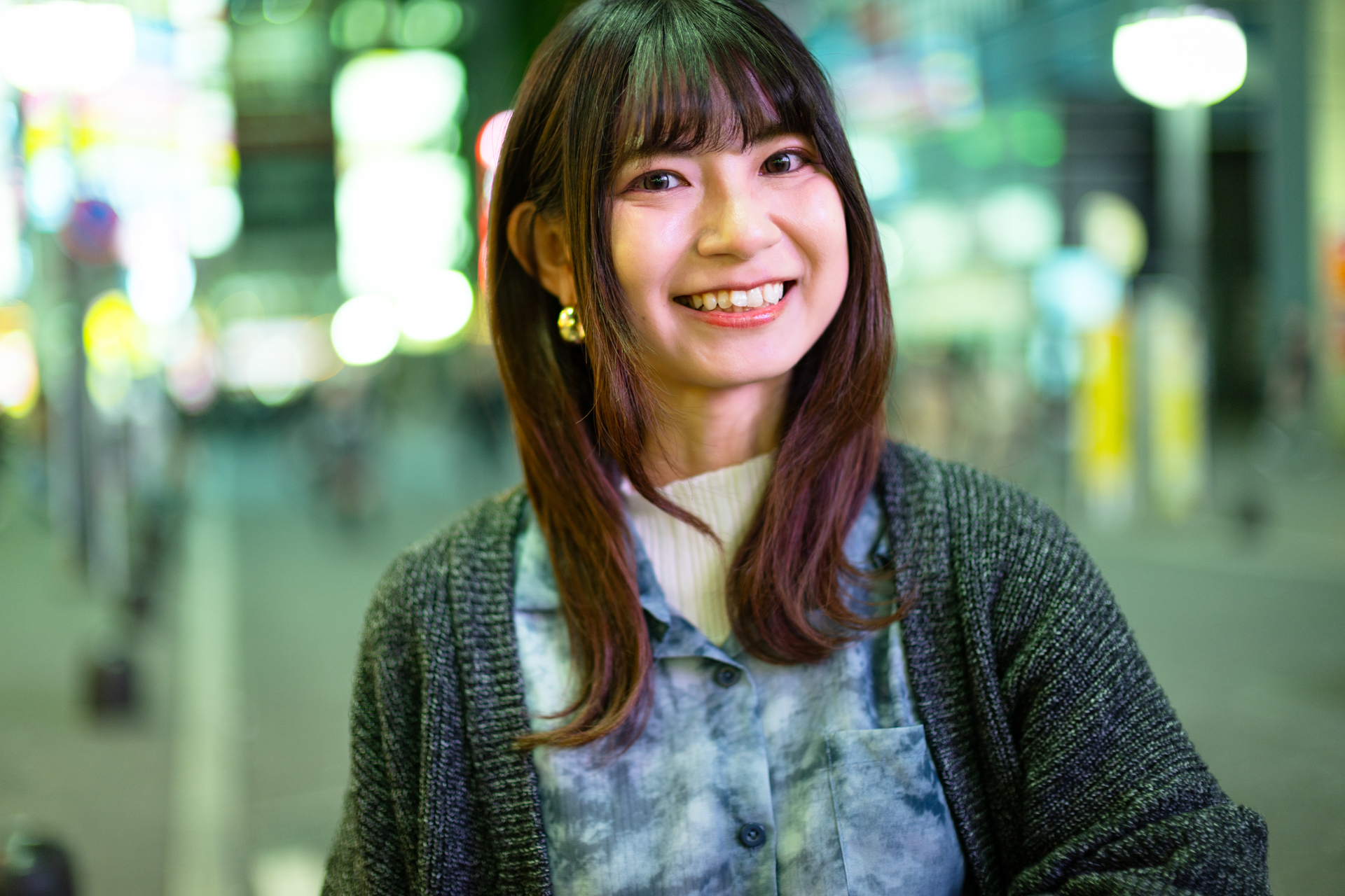 夜の新宿で、居酒屋の看板の明かりだけで撮影してみました。いかにもテスト撮影のためにここを選びましたというのが自分でも少し気になるのですが、背景までの距離があるためか、光源ボケもいい感じで救われています。モデル：ひぃな<br><span class="fnt-85">キヤノン EOS R6 Mark III／RF45mm F1.2 STM／45mm／絞り優先AE（1/200秒、F1.2、0.67EV）／ISO 400</span>