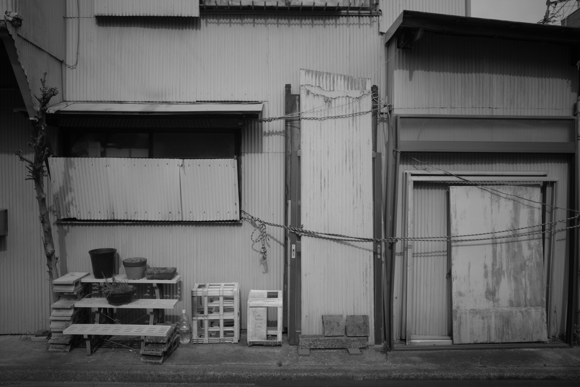 こうした光景をつい撮影してしまうのは、写真家の武田花さんの作品も好きで影響を受けているからです。スタンダードで「眠そうな町」調になりましたので、これでいいかと。<br><span class="fnt-85">RICOH GR IV Monochrome／GR IV LENS 18.3mm F2.8／絞り優先AE（1/2,000秒、F4.5、−1EV）／ISO 800／イメージコントロール: スタンダード</span>