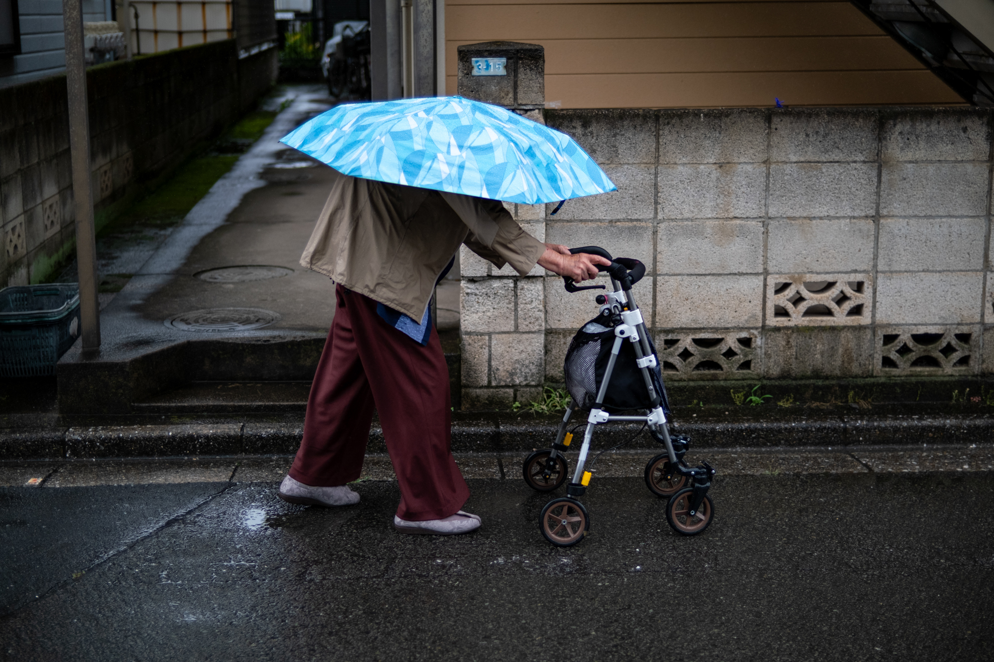 雨の日です。遭遇した時、傘に足が生えて歩いていると思いました（笑）。撮影距離はありますけど、F1.4設定ではまだ被写界深度が浅く人物全体はピリッとこない感じです。<br><span class="fnt-85">富士フイルム X-T30 III／NOKTON 35mm F1.2／35mm／絞り優先AE（1/2,900秒、F1.4、−0.67EV）／ISO 400</span>