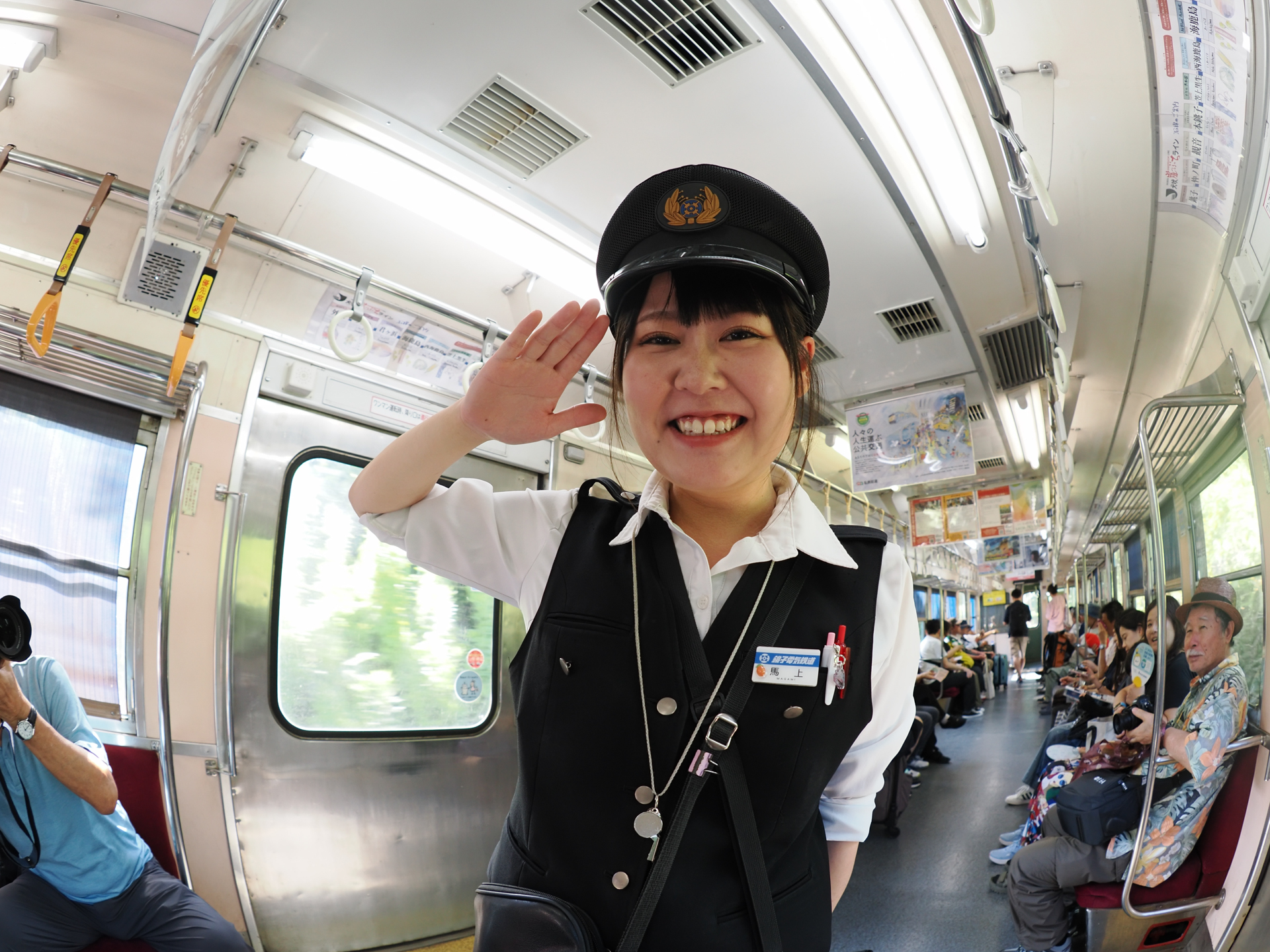 銚子電鉄の車掌さんです。可愛い愛想のいい車掌さんに検札してもらえるなら、おじさんは嬉しい。でも装着レンズが魚眼ですので思い切り歪みました、すみません。お詫びします。銚子電鉄は愛称を「犬吠崖っぷちライン」として、風景と経営難をかけて、自虐的に名付けています。乗りに行って応援しましょう。<br><span class="fnt-85">オリンパス OM-1／M.ZUIKO DIGITAL ED 8mm F1.8 Fisheye PRO／8mm／絞り優先AE（1/100秒、F3.2、±0.0EV）／ISO 400</span>