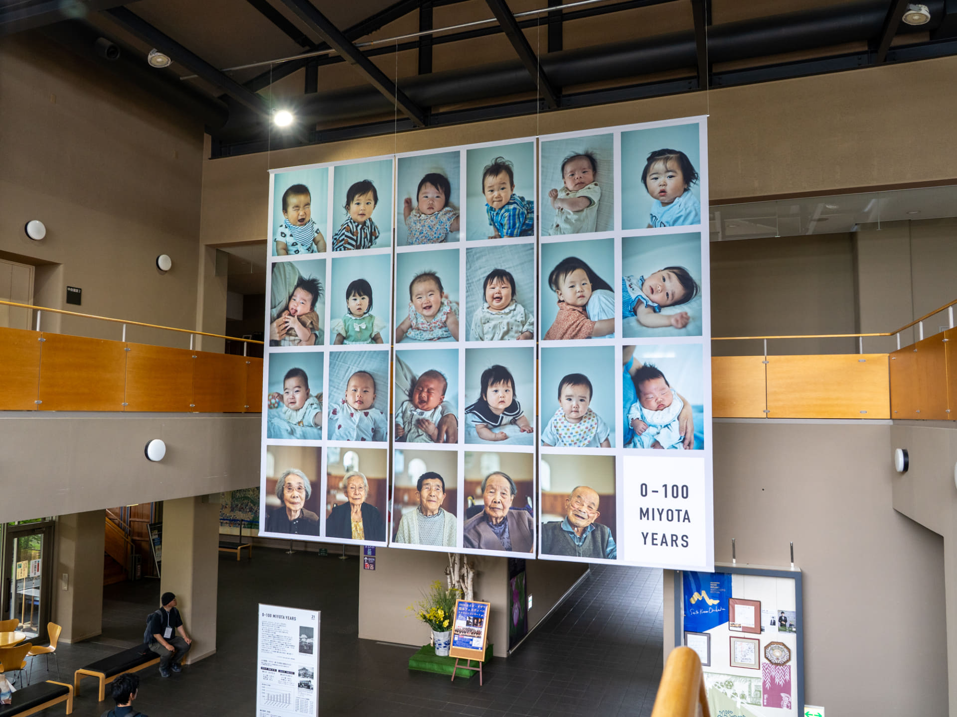 近隣の公民館エコールみよたのエントランスに掲示された作品。町内に暮らす0歳児と満100歳のお年寄りを撮影した栗田萌瑛+ミヨタデザイン部による「0-100 MIYOTA YEARS」