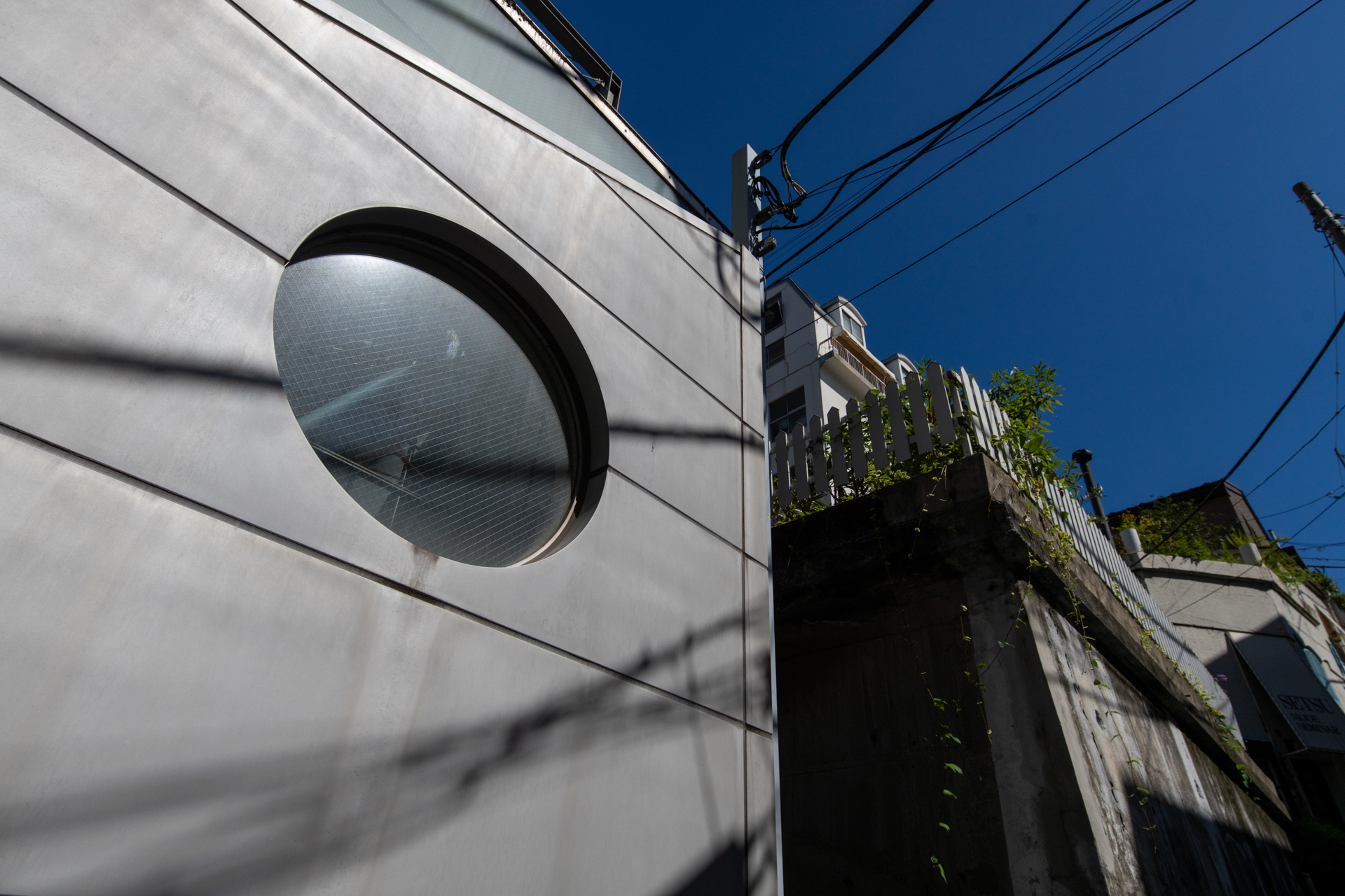 坂の途中ですし、引きがありませんから見上げるアングルしかないわけです。それでも、見苦しさは避けたいので、カメラを捧げ持ったり、焦点距離を選んだりして苦労しているのであります。<br><span class="fnt-85">ソニー α7RC／TAMRON SP 15-30mm F/2.8 Di VC USD A012S／18mm／絞り優先AE（1/4,000秒、F8、−1EV）／ISO 400</span>