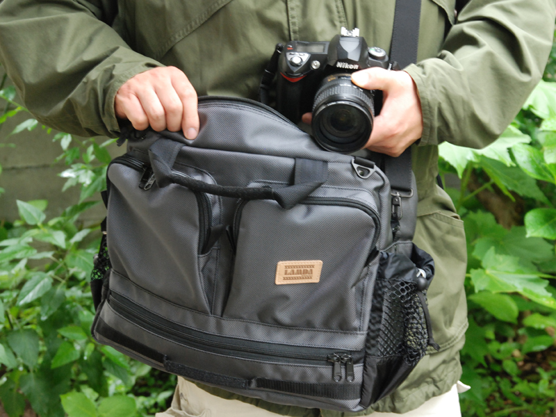 <b>バッグを前に回して機材を出し入れしているところ</b>