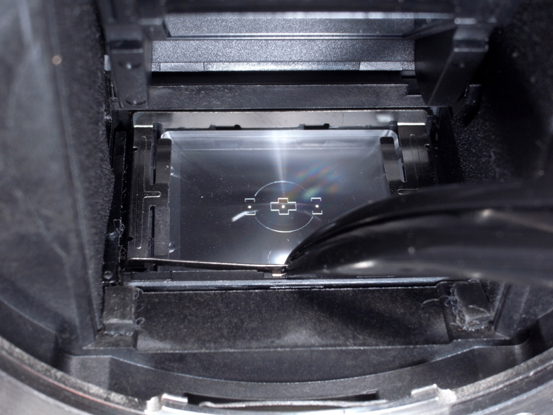 <b>フォーカシングスクリーンの押さえ板の手前中央をピンセットでつまみ、奥の方へちょっとだけ押す</b>