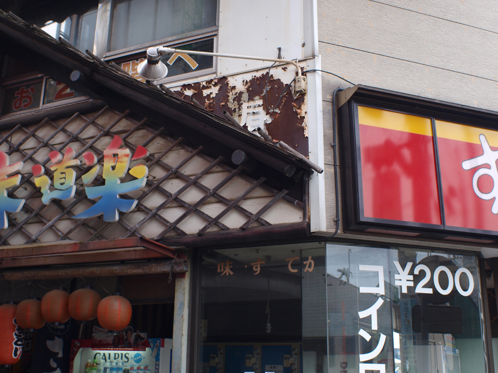 <b>「味　・す　てカ」の周囲も、まさに混沌とした状態。錆に埋もれる「昼」の一字も意味不明。この建物の増改築の歴史を物語っている</b>